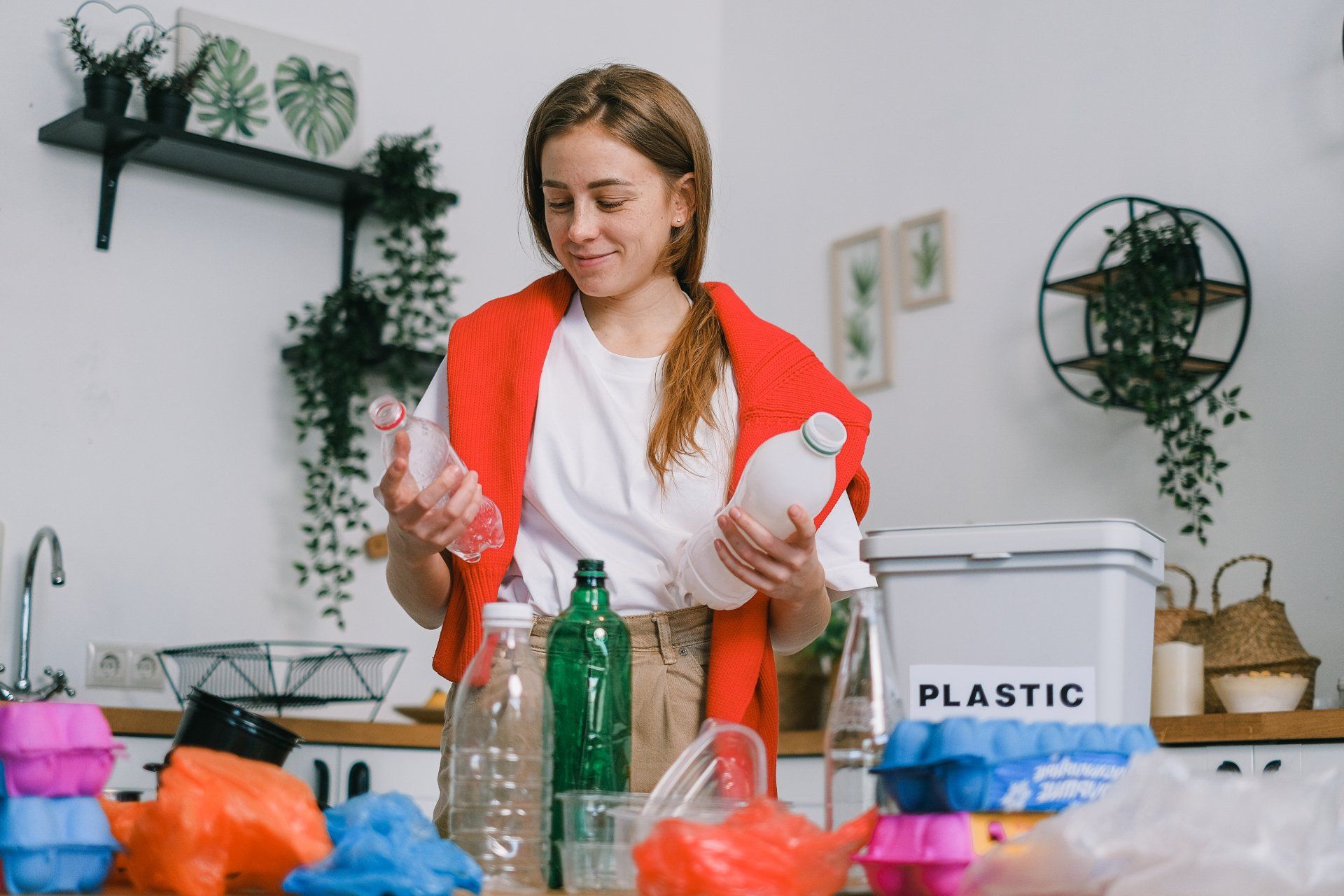 Young woman sorting plastic bottles for recycling.