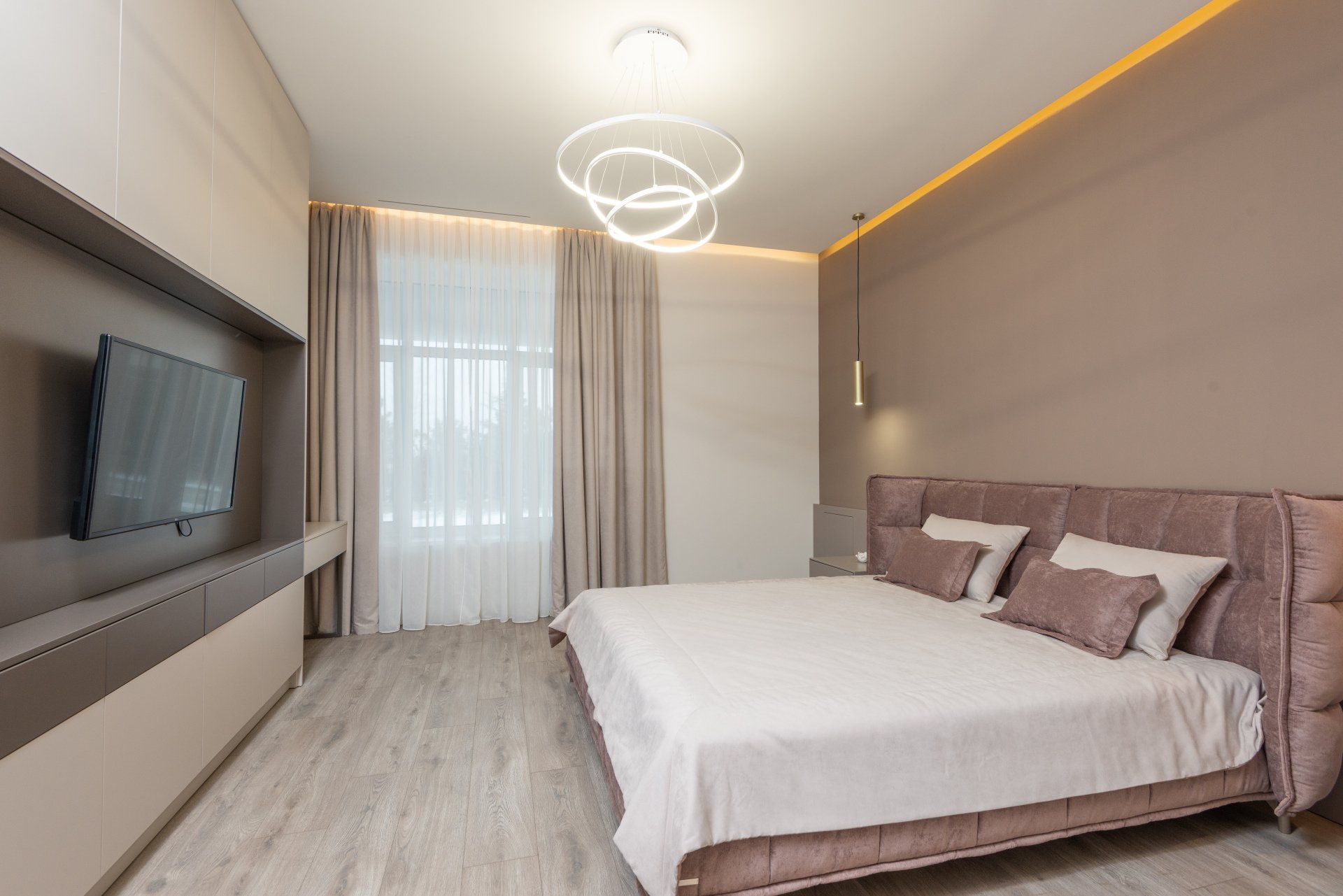 A bedroom with a large bed and a flat screen tv.