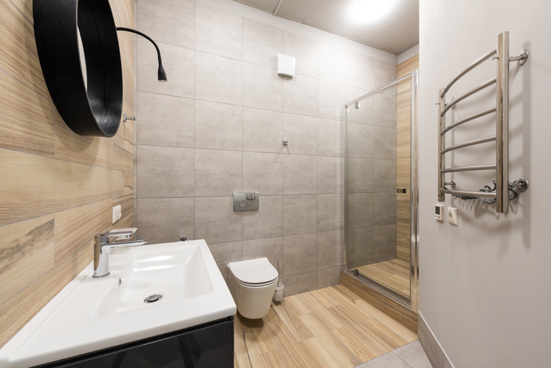 A modern industrial themed bathroom with a tan tile accent wall.