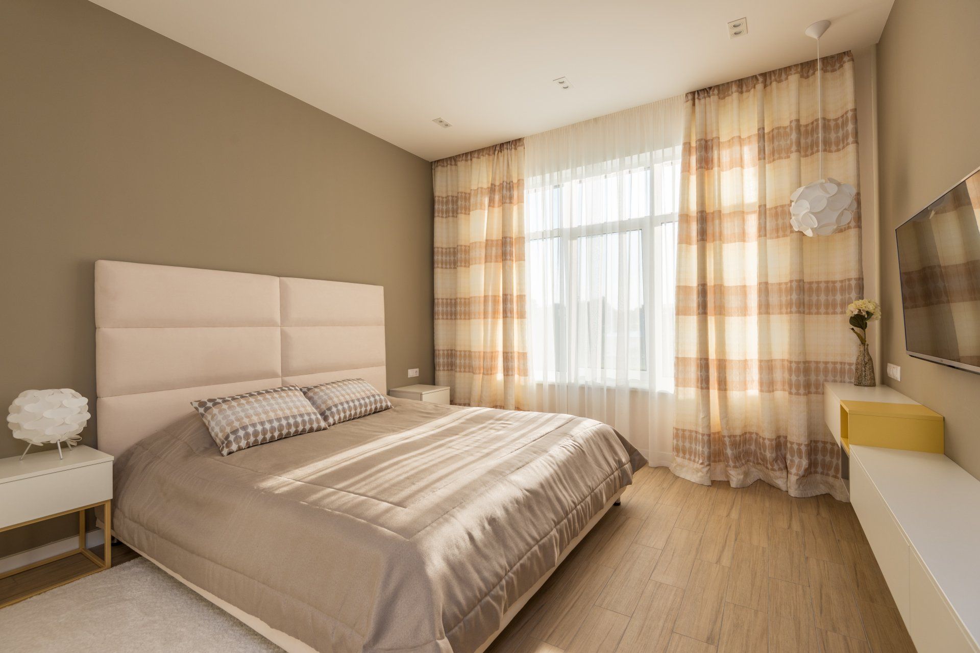 Warm bedroom setting with layered patterned drapes highlighting cosy curtains for sale.