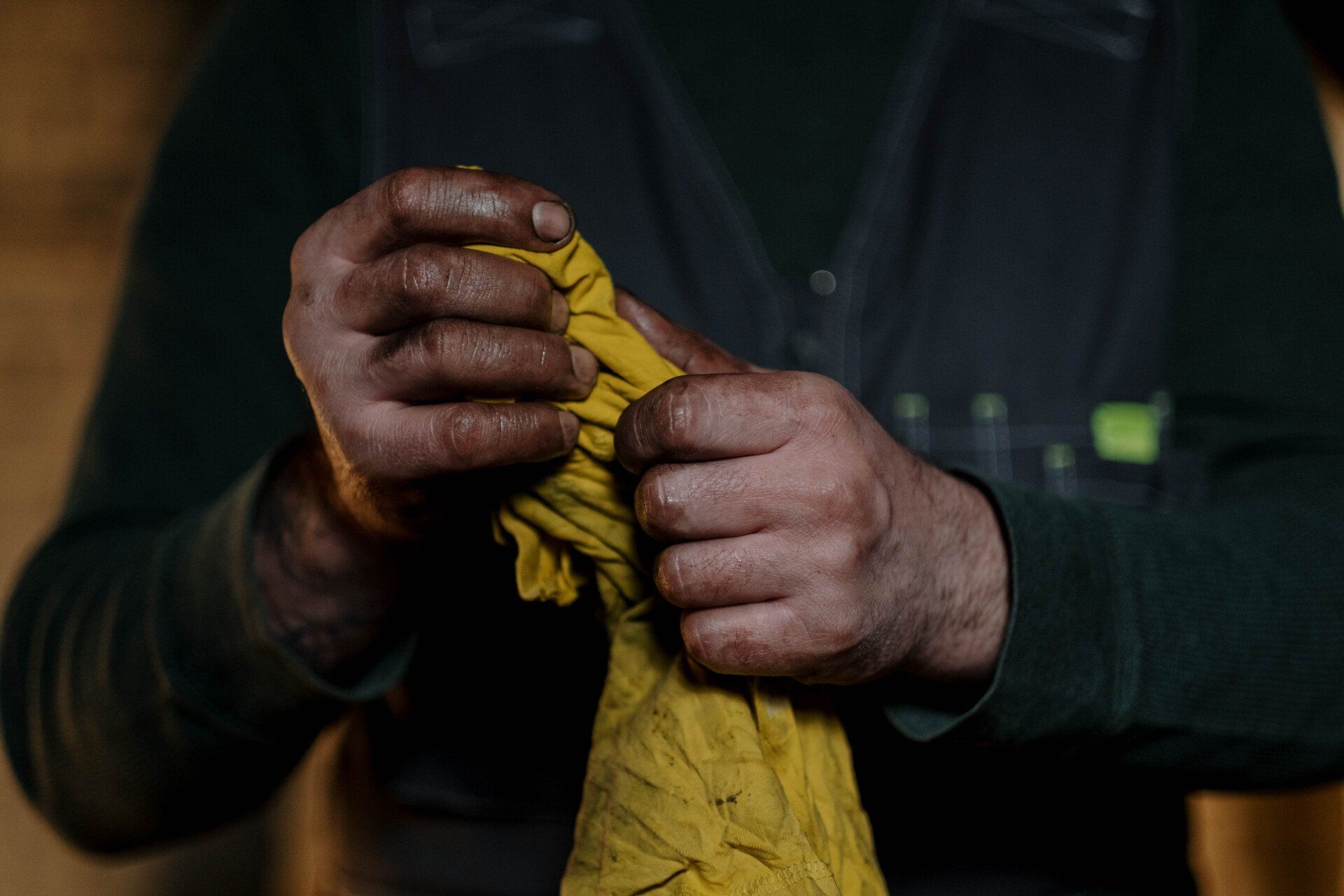 Mechanic wiping greasy hands with yellow towel
