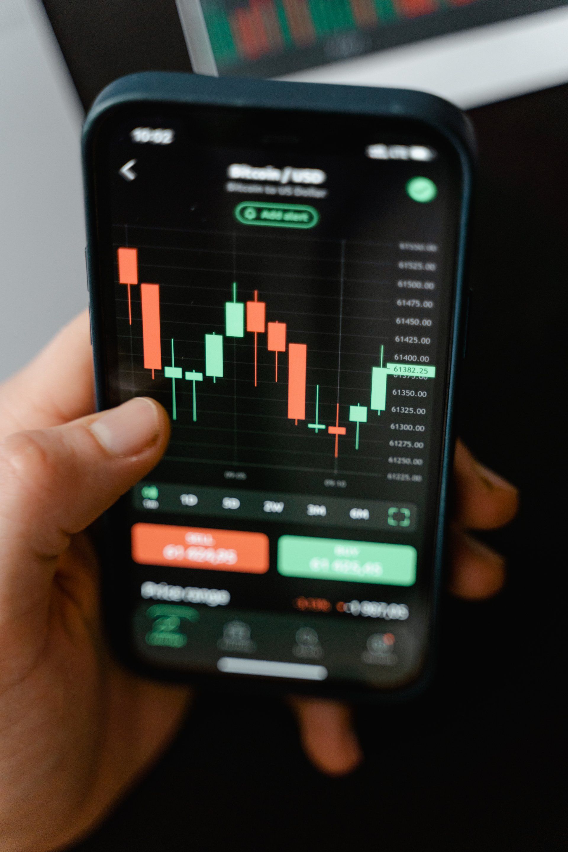 A trading screen and candlestick chart on a phone