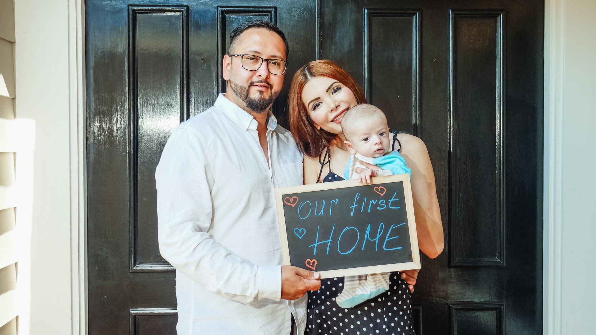 Couple and Baby Holding a Sign