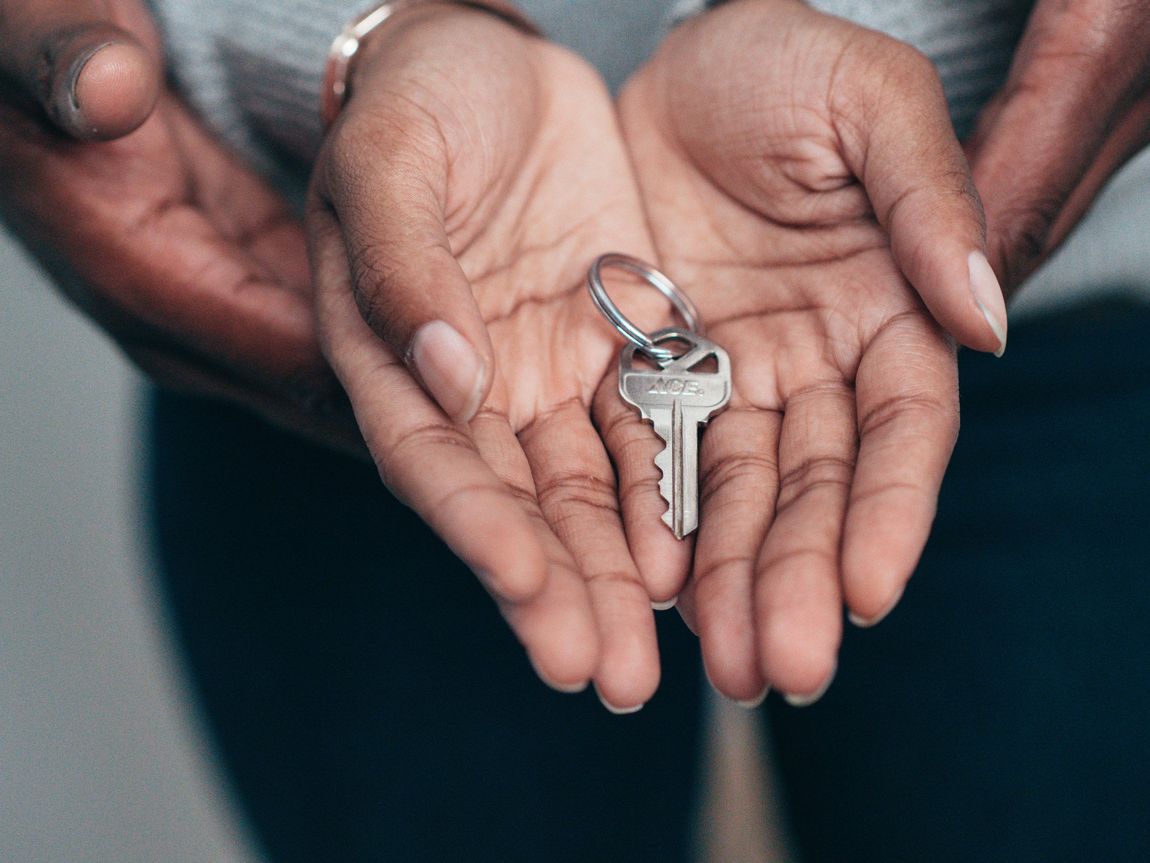 a person is holding a key in their hands .