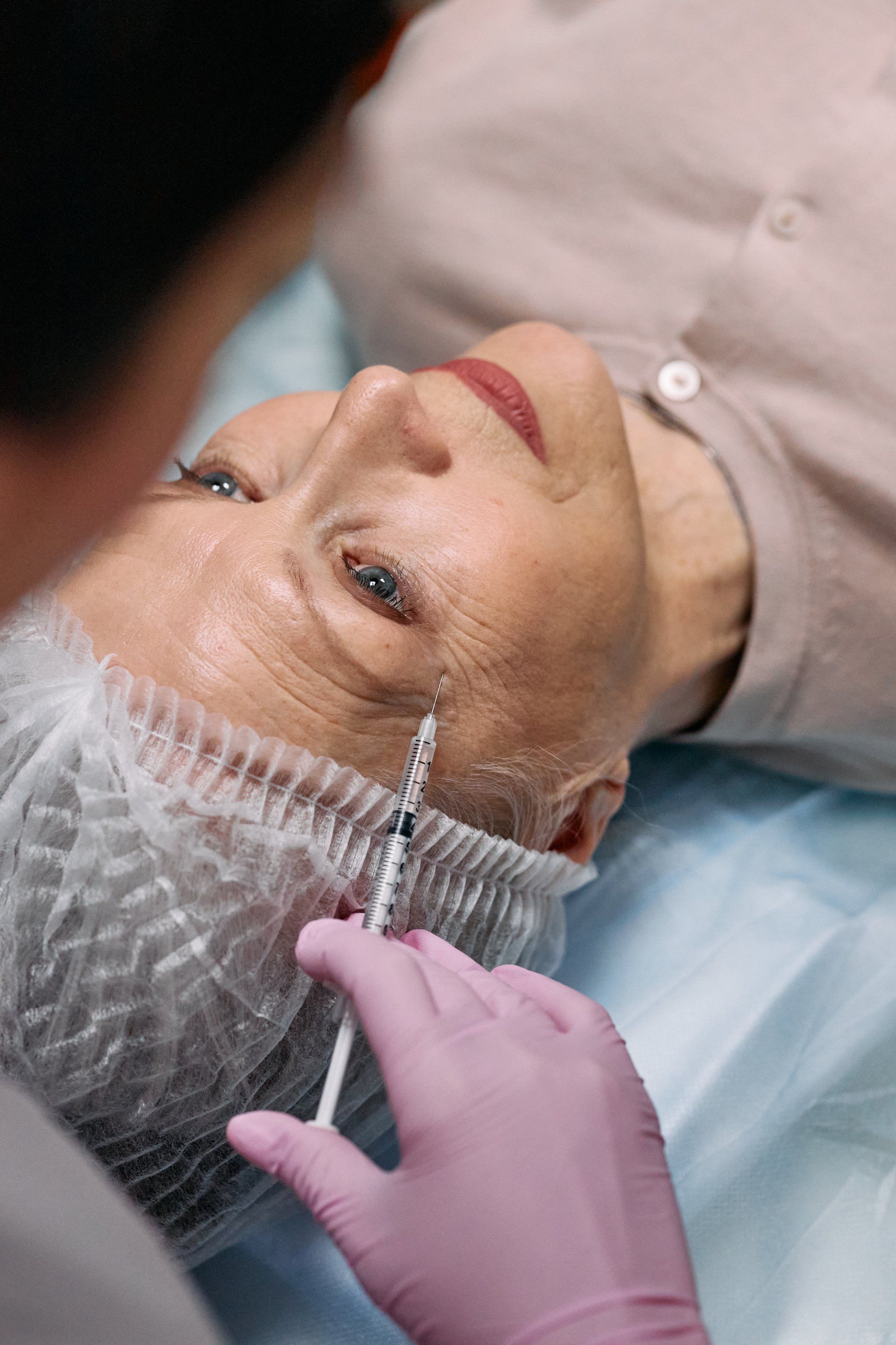 A woman is getting a botox injection in her face.