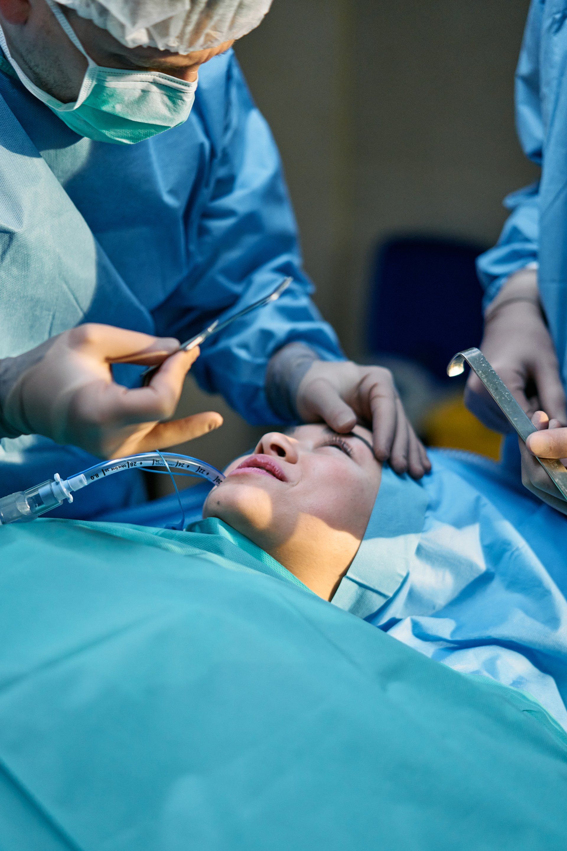 Close-up photo of a surgeon carefully performing a facelift procedure on a patient's face.