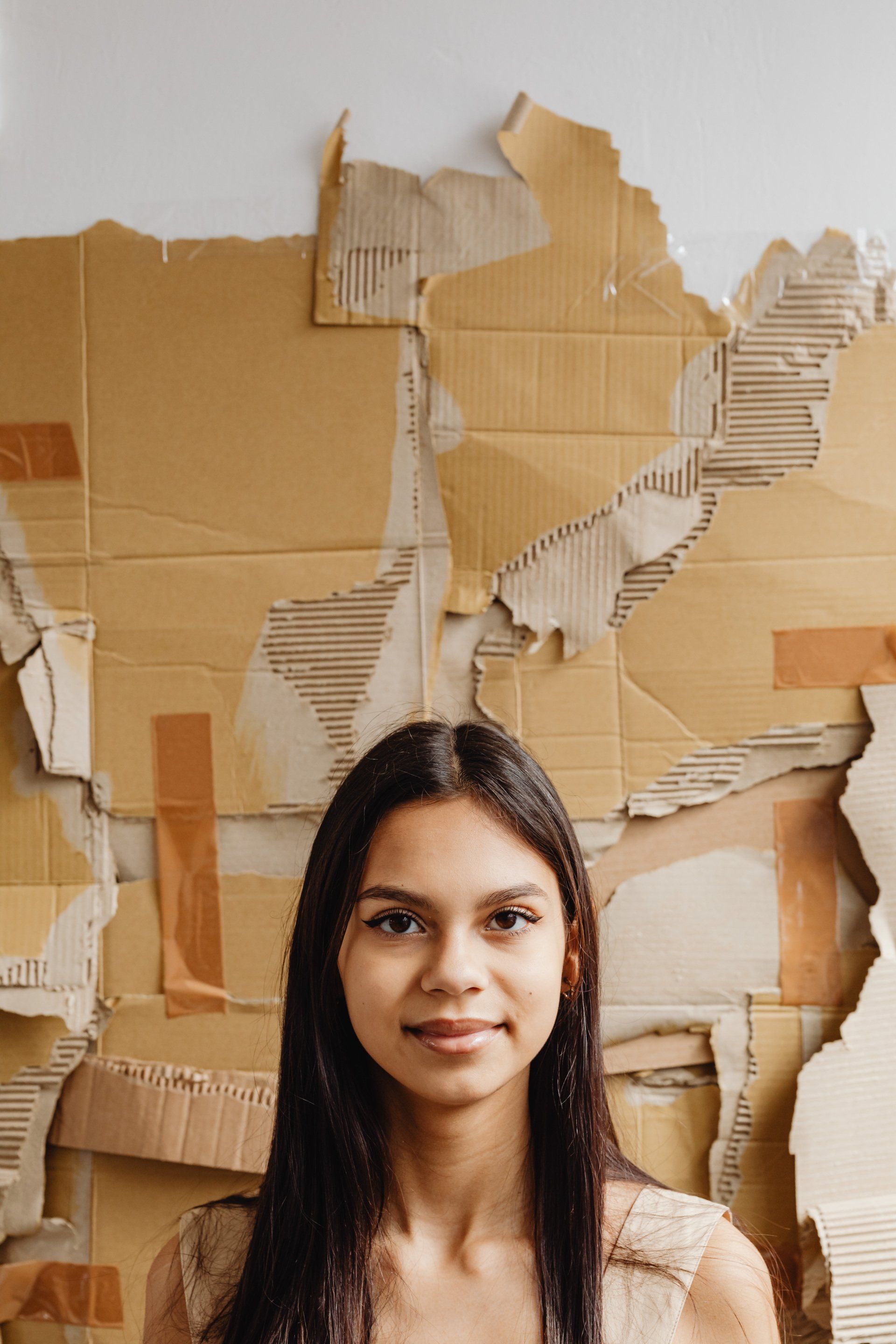 a woman with brown boxes taped on the wall behind