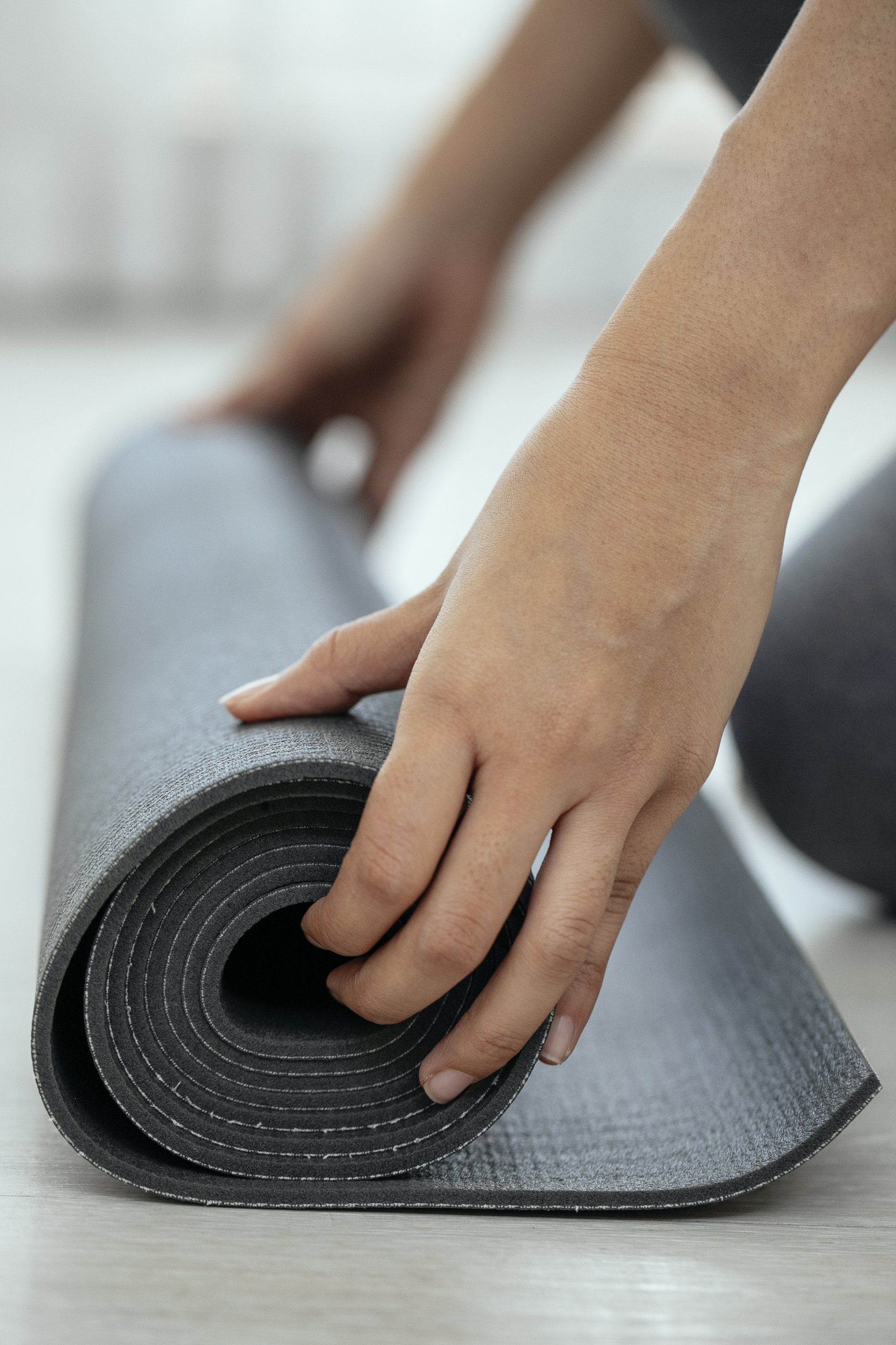 a person is rolling a yoga mat on the floor .