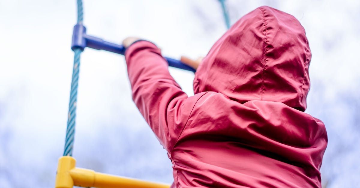 A child is climbing a rope ladder at a playground.