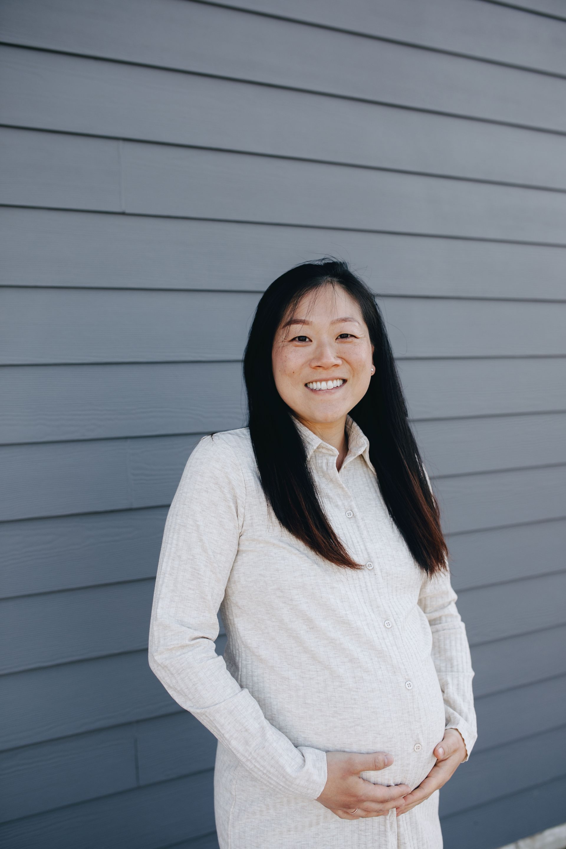 A  pragnent woman standing with gray background