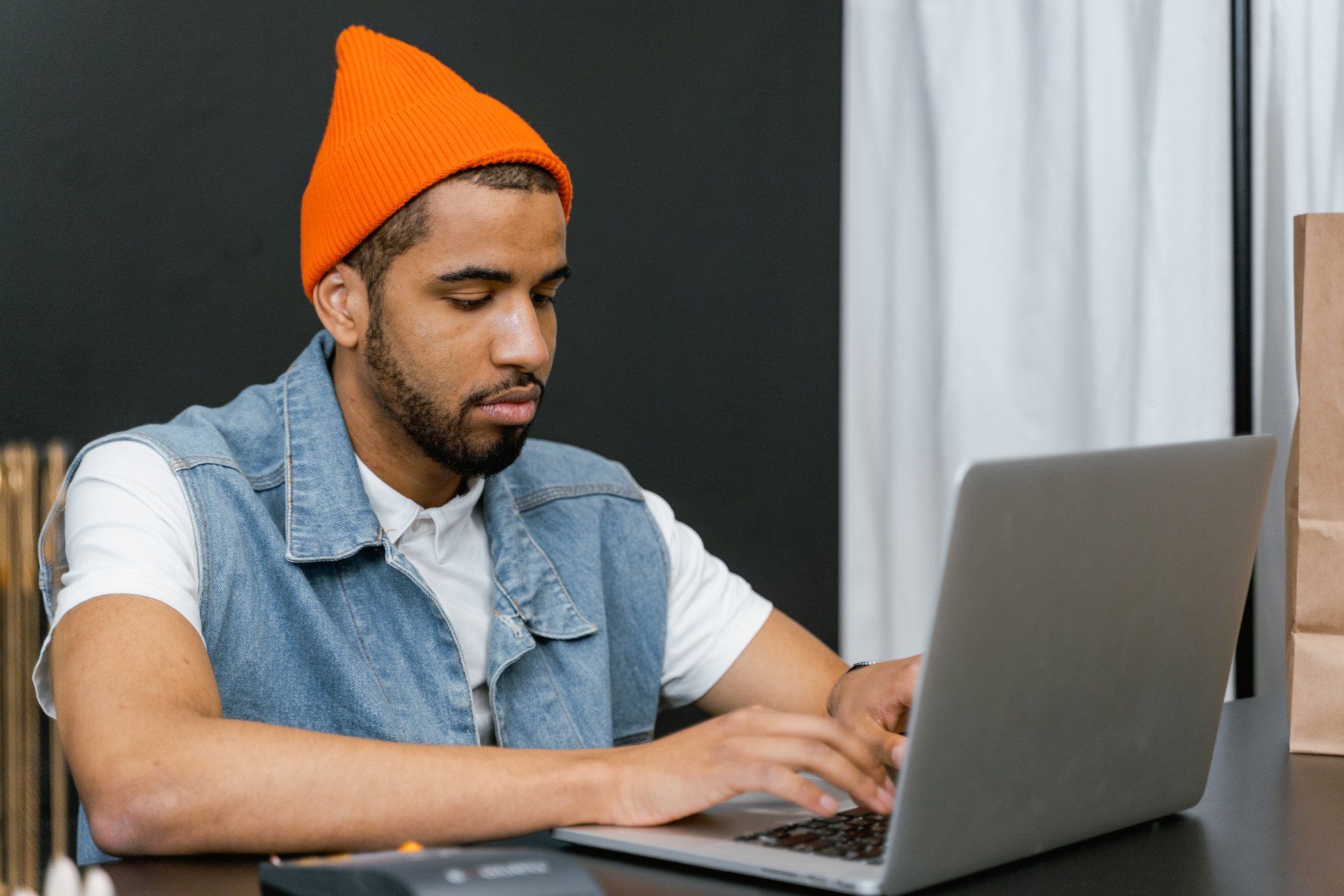 A man is sitting at a desk using a laptop computer.