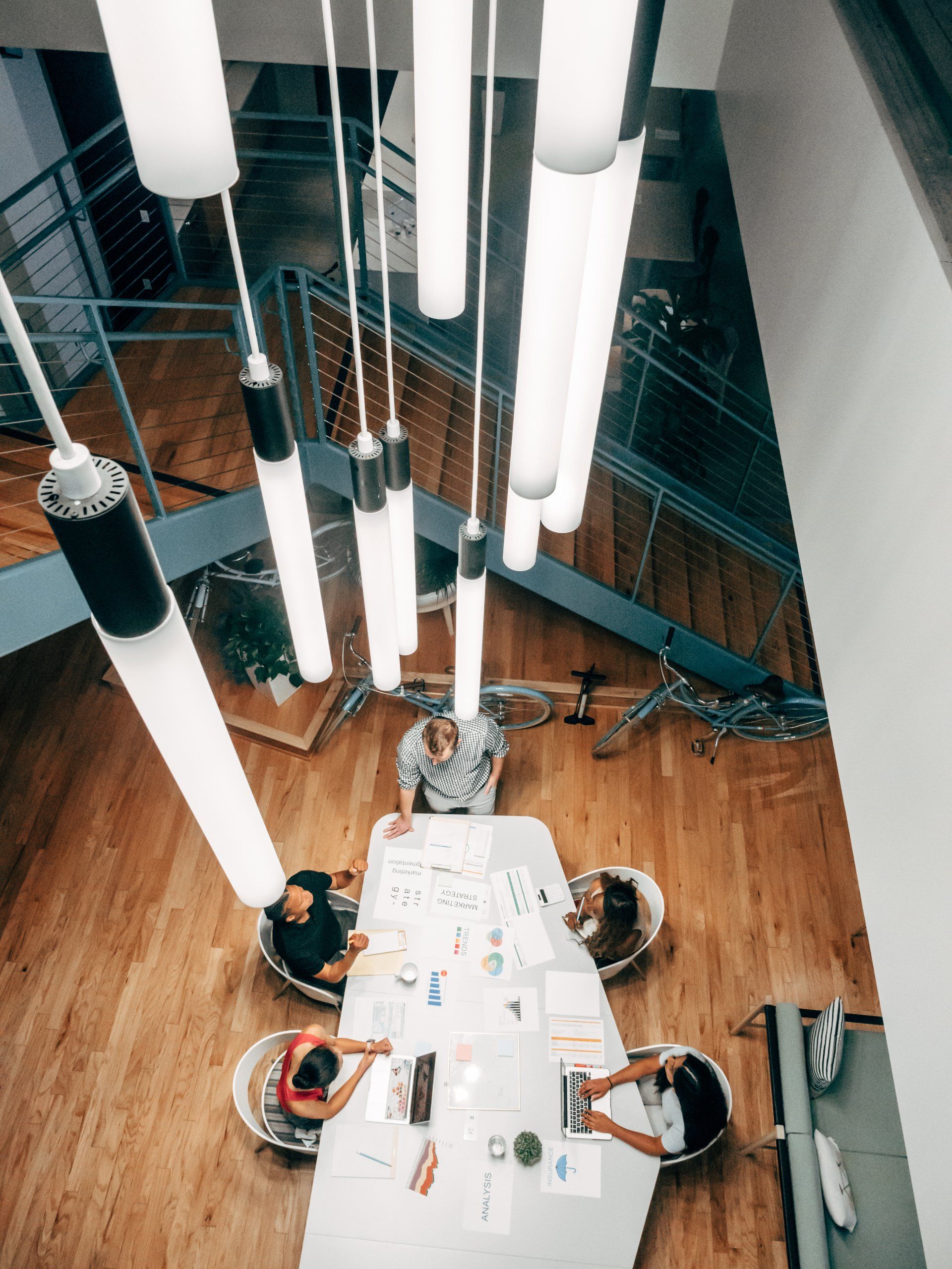 A group of people are sitting around a table under a chandelier.