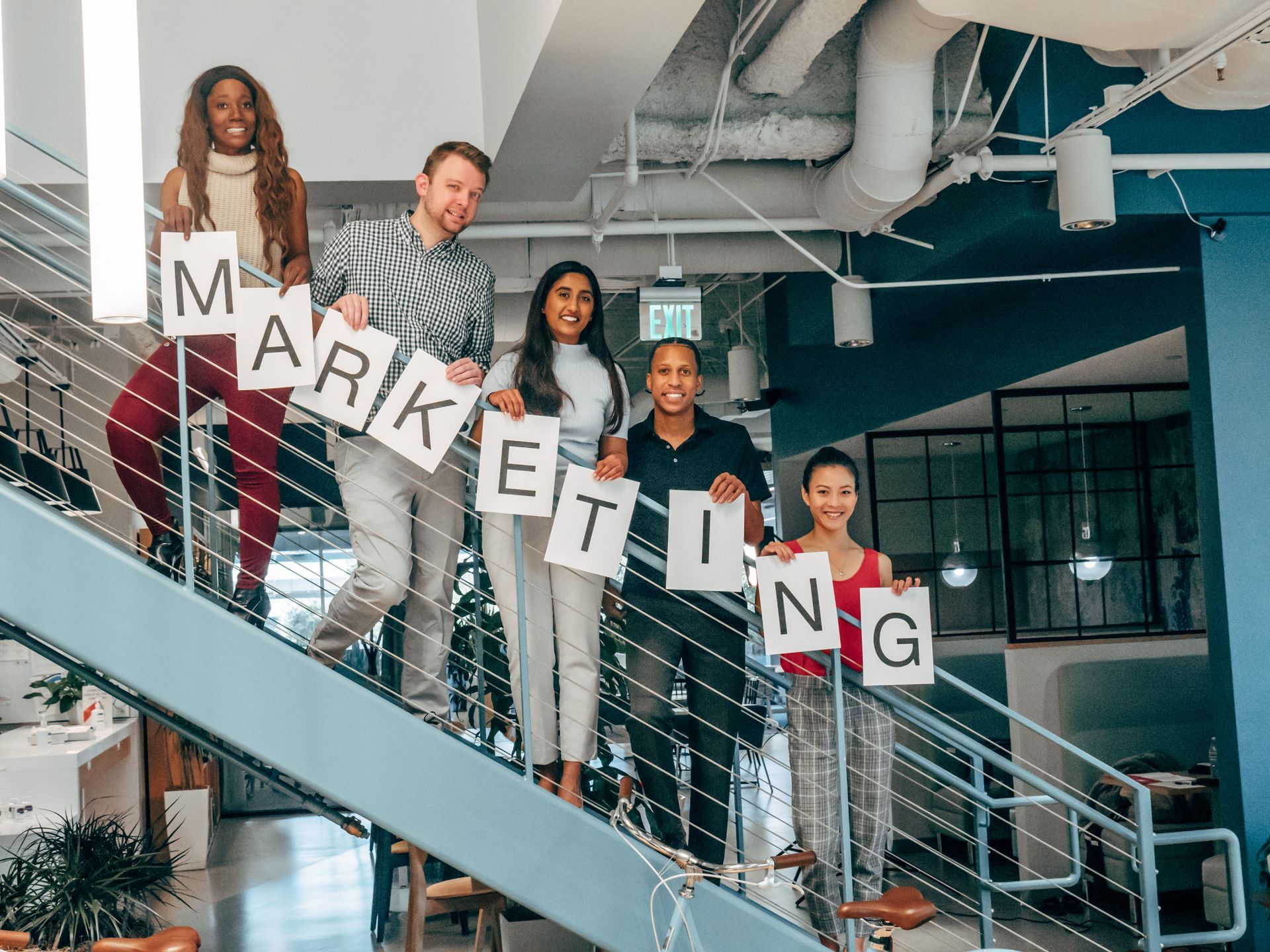 a group of people are standing on a set of stairs holding signs that say marketing .