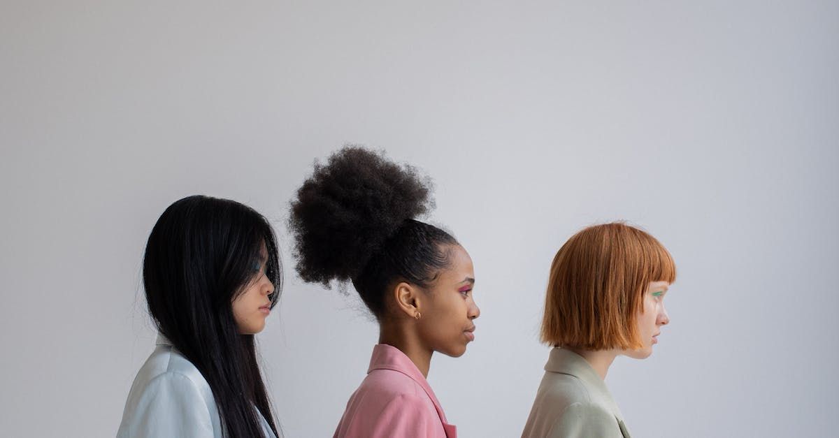 Three women are standing next to each other in a row.