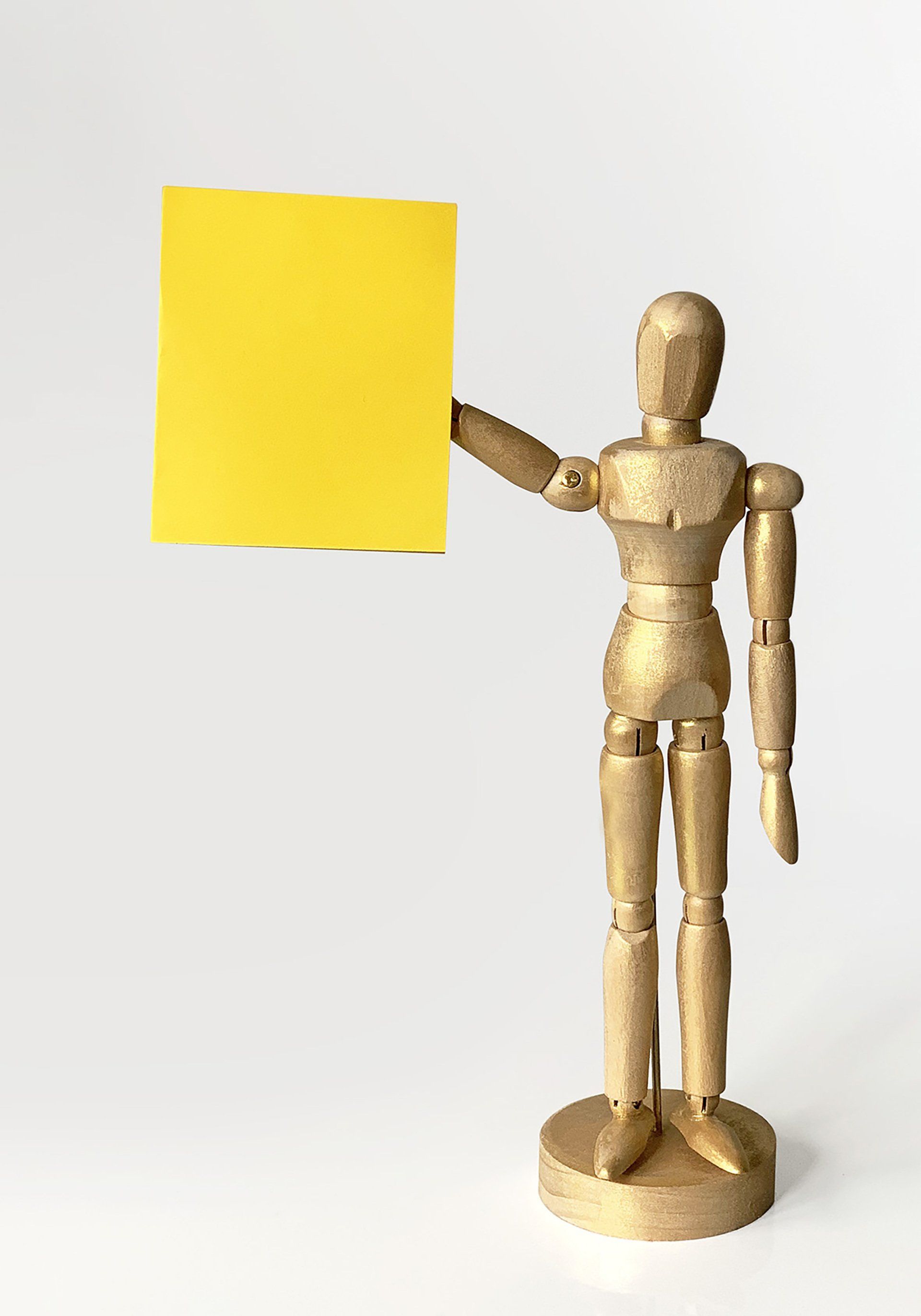 A small figurine holding a post-it note