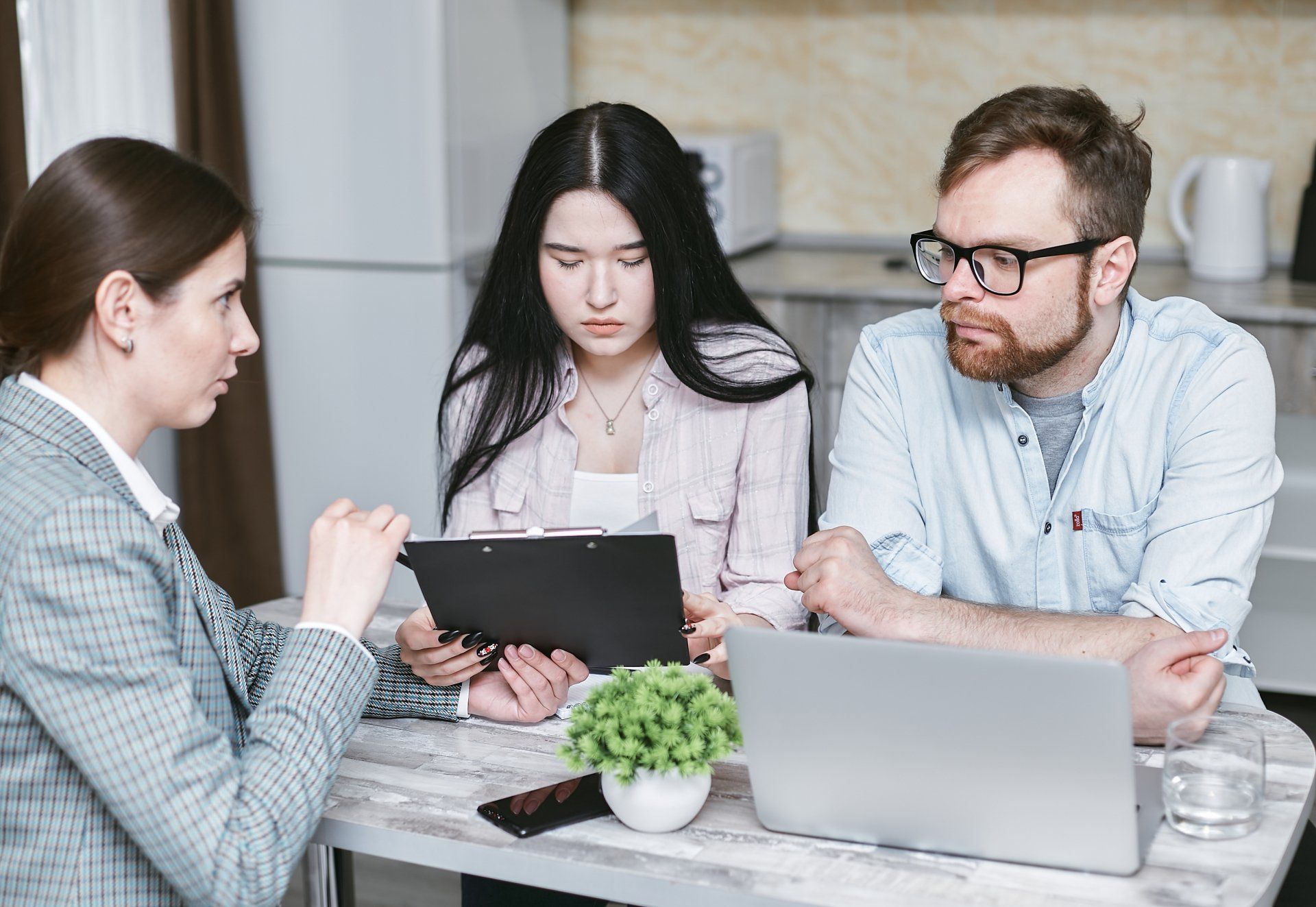 a man and a woman are sitting at a table with a laptop .