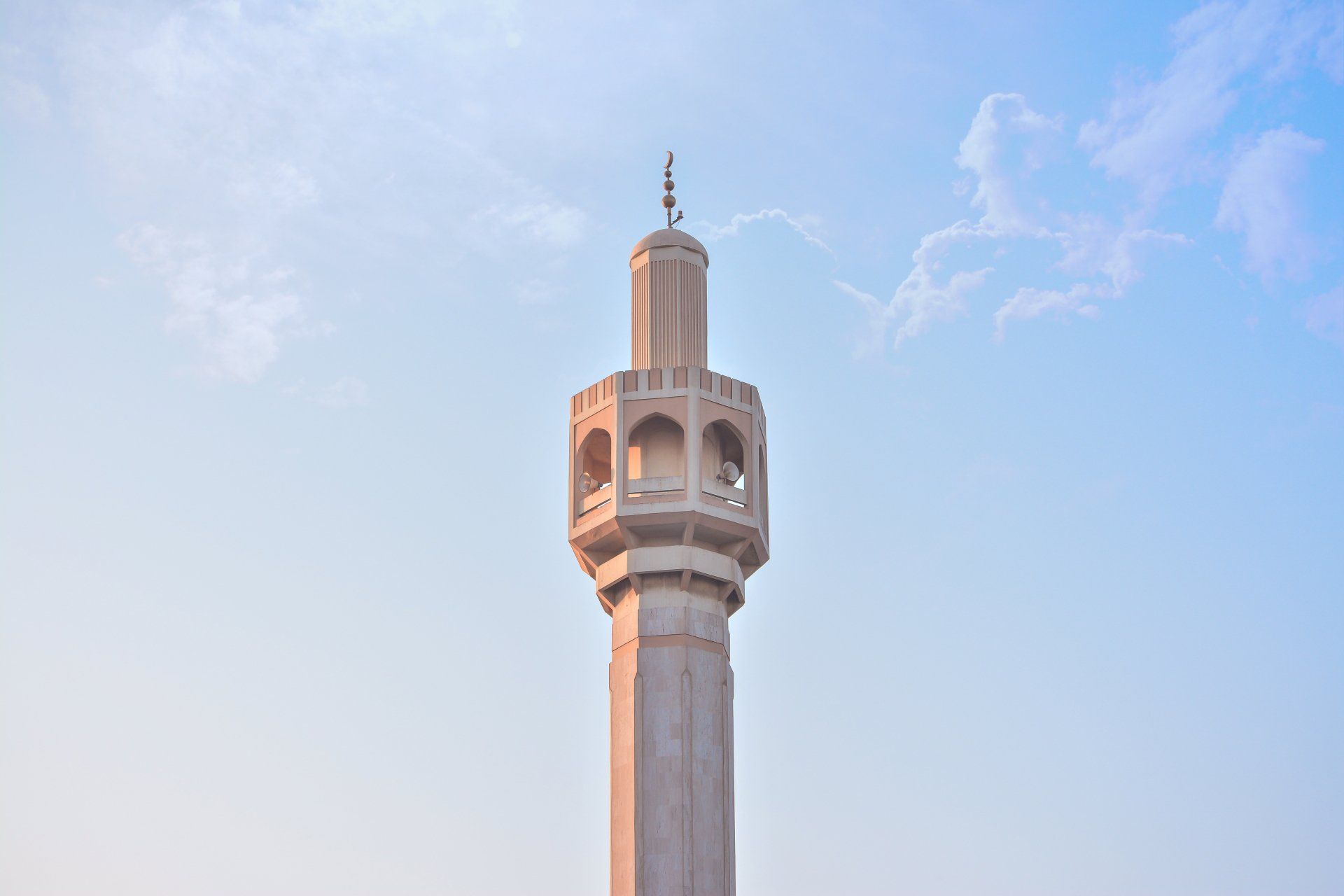 A very tall tower with a blue sky in the background.