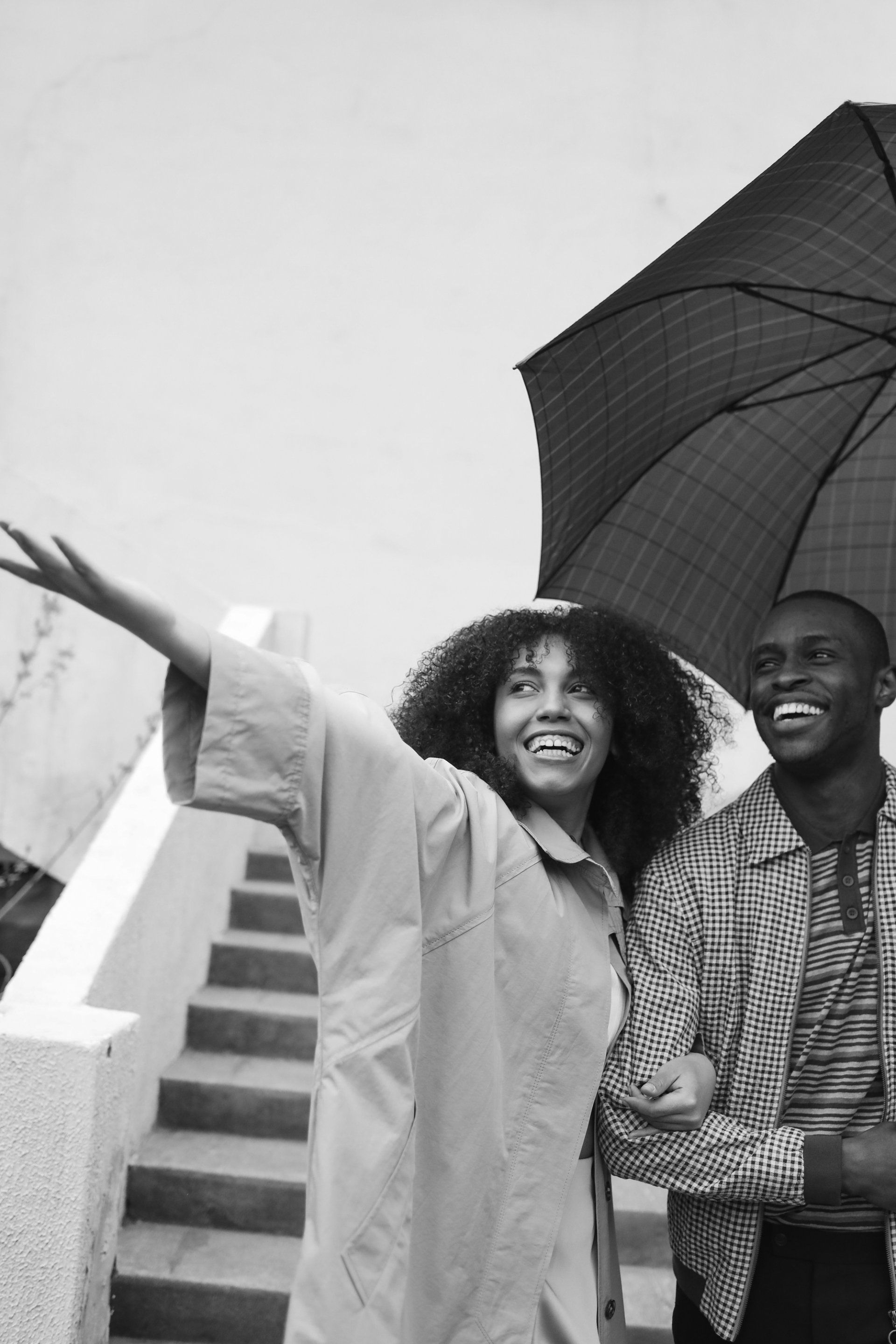 A man and a woman are holding umbrellas in the rain.