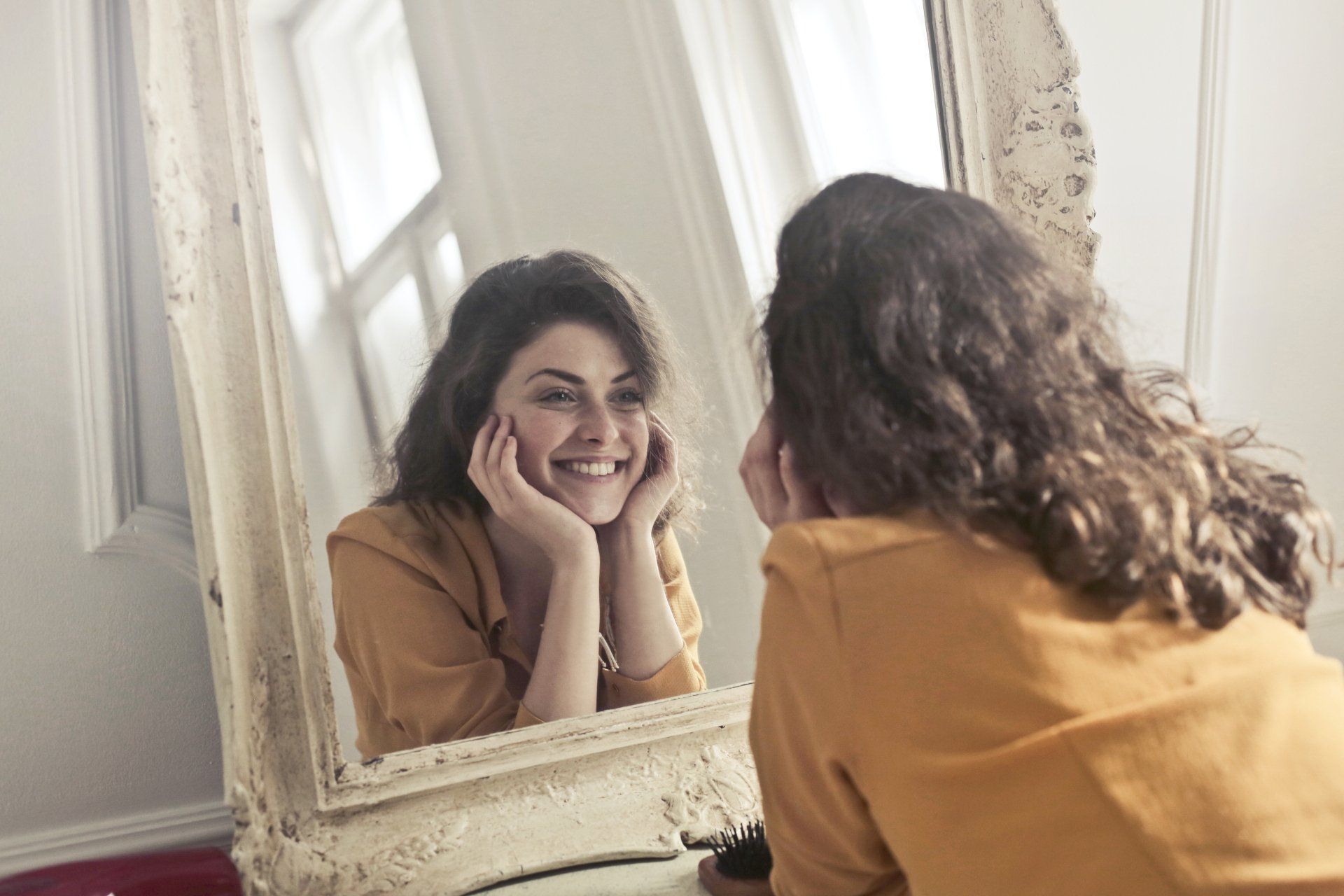 Woman smiling holding face in mirror | Villa Rica, GA