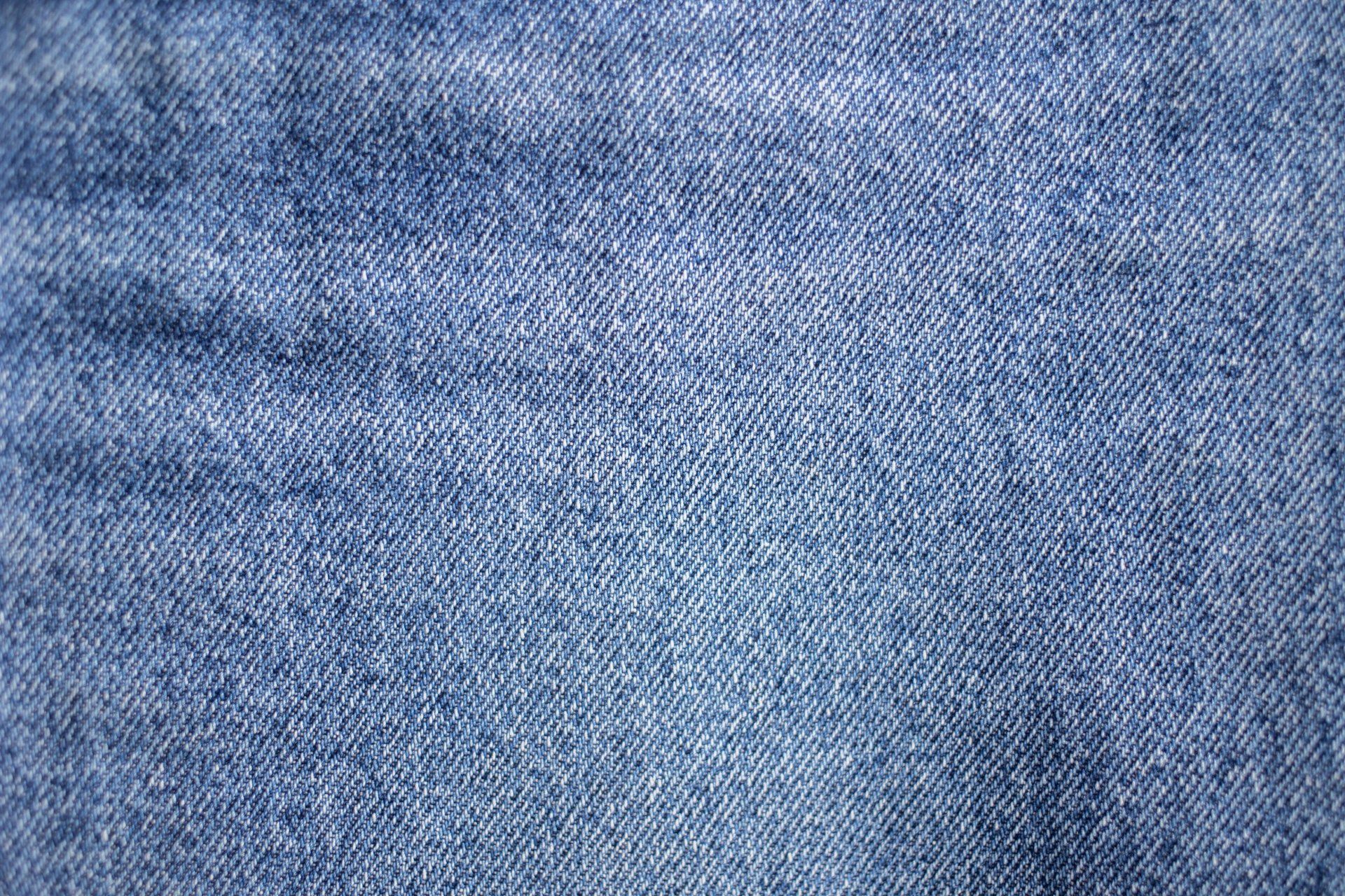 A close up of a blue denim fabric texture.