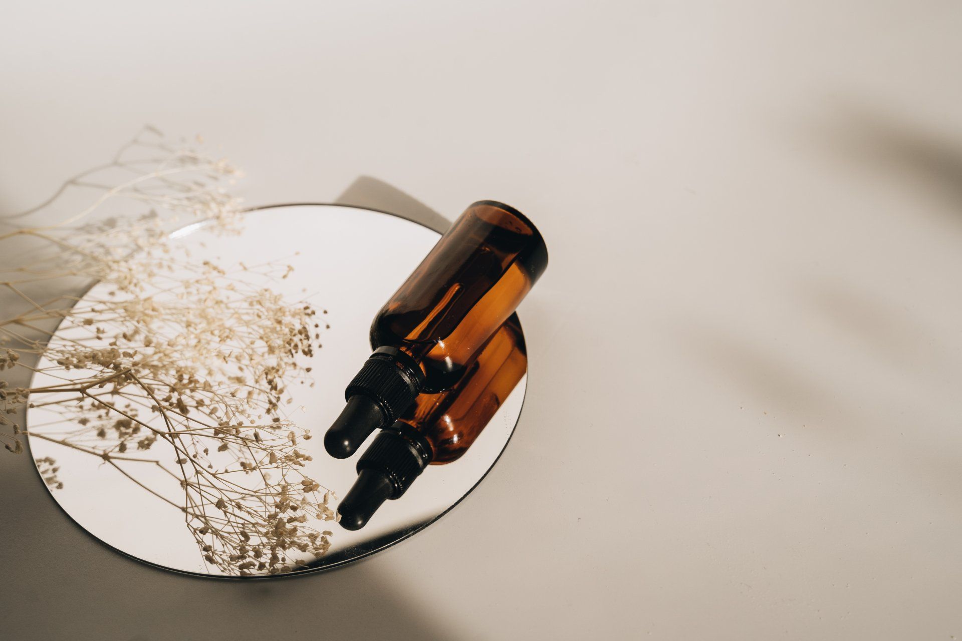 Bottle of essential oil sitting on a mirror.