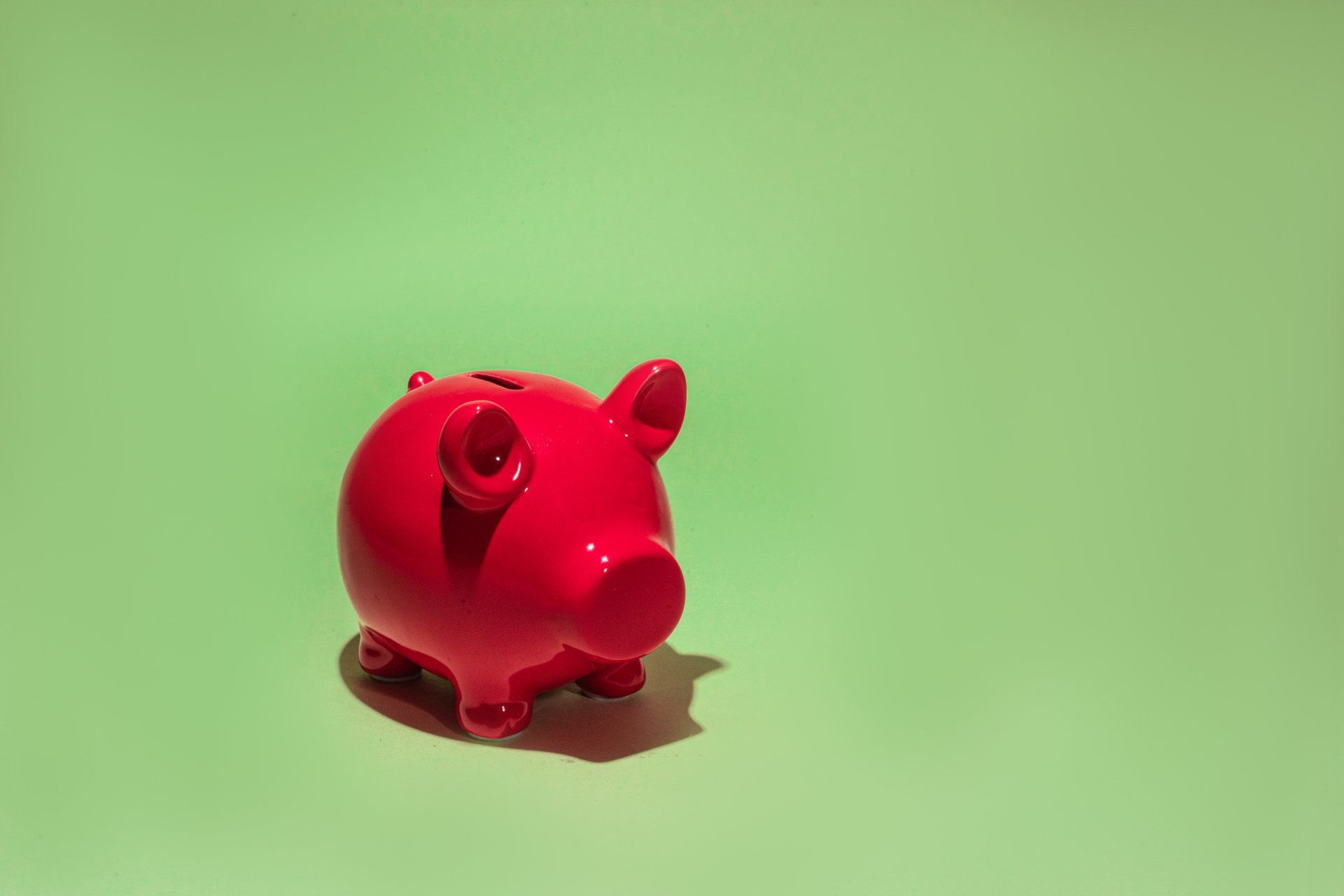 a red piggy bank is sitting on a green surface