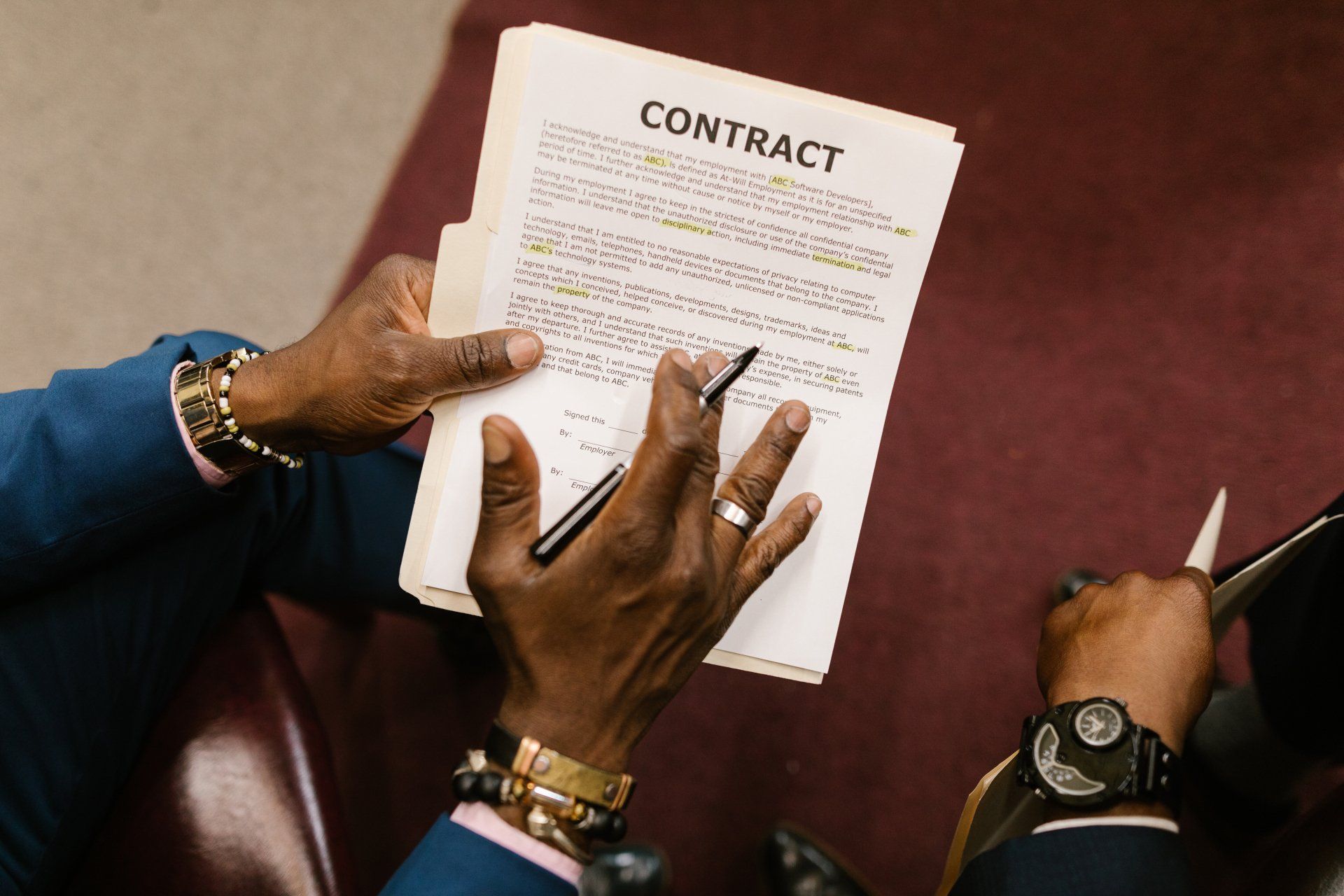 A man is signing a contract with a pen.