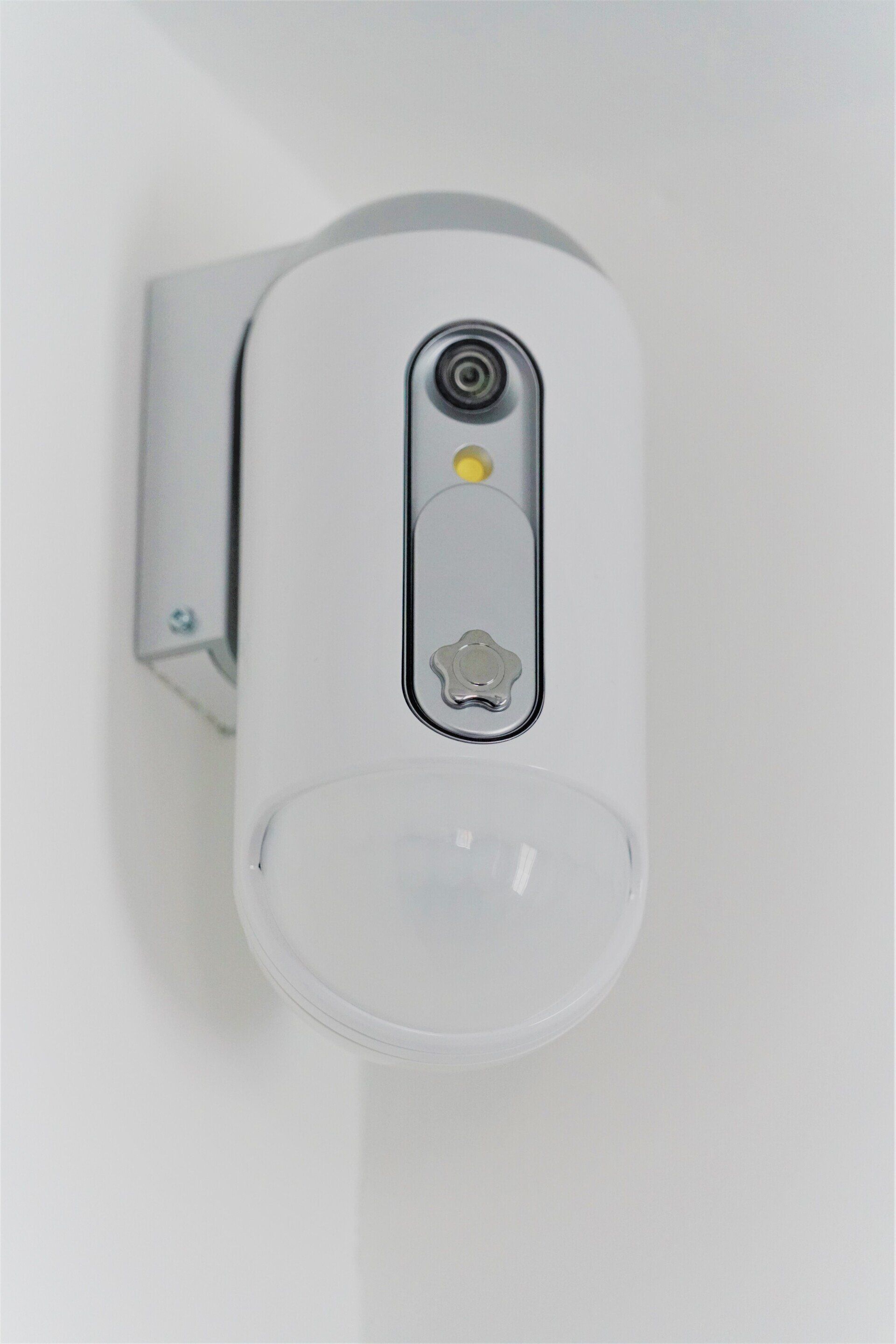 a white motion sensor is mounted on a white wall .