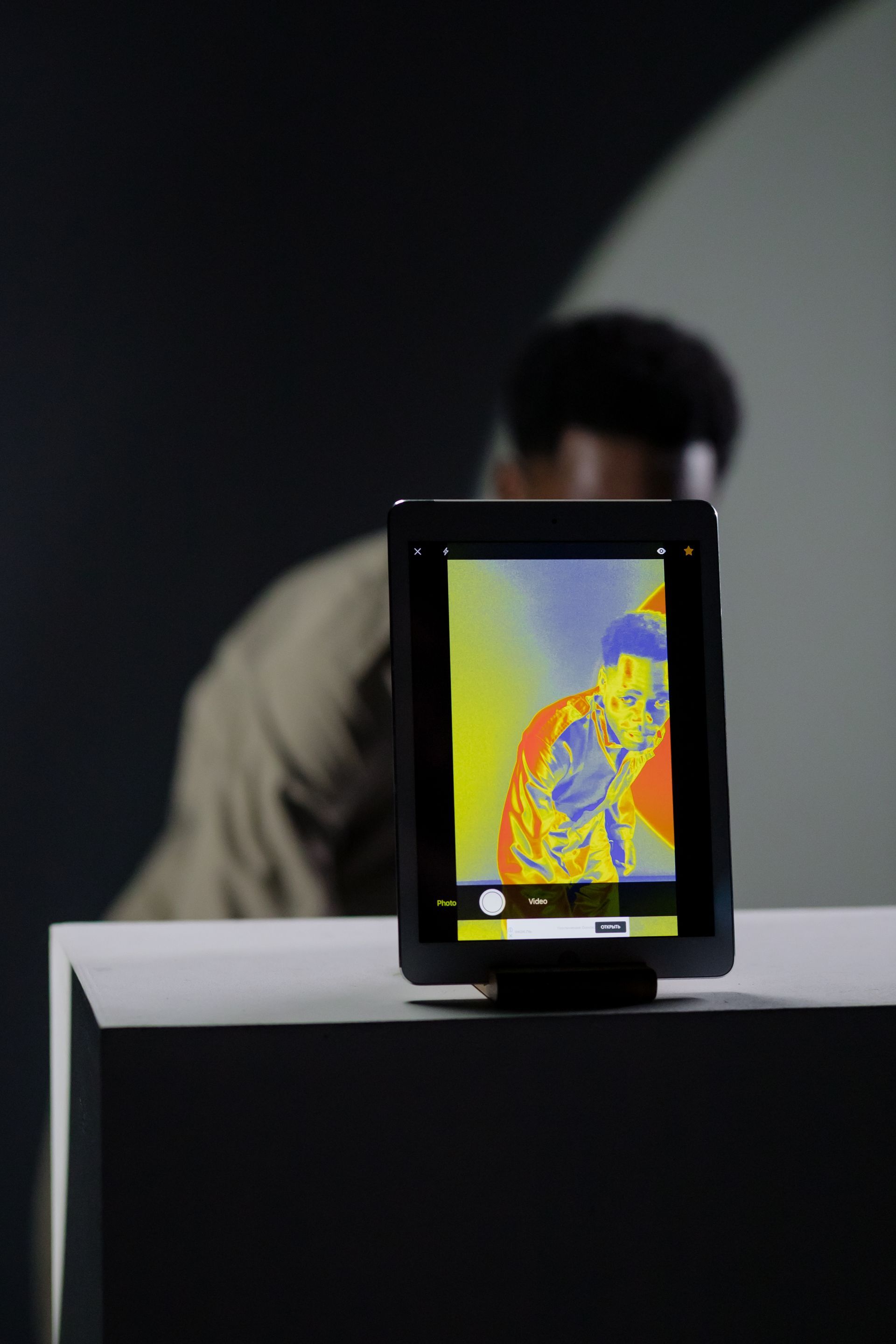 A thermal image of a person is displayed on a tablet