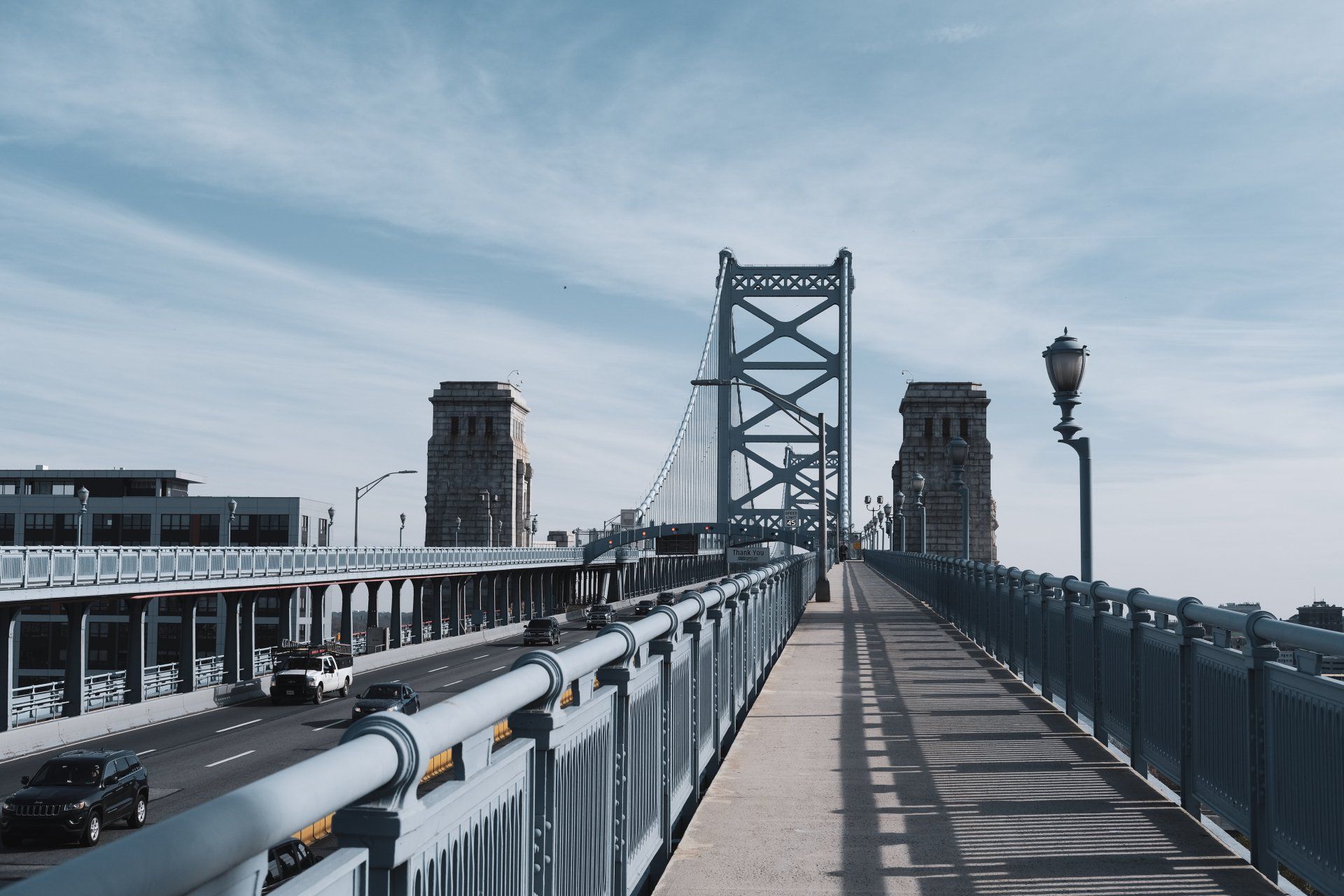 A bridge over a highway with cars driving on it