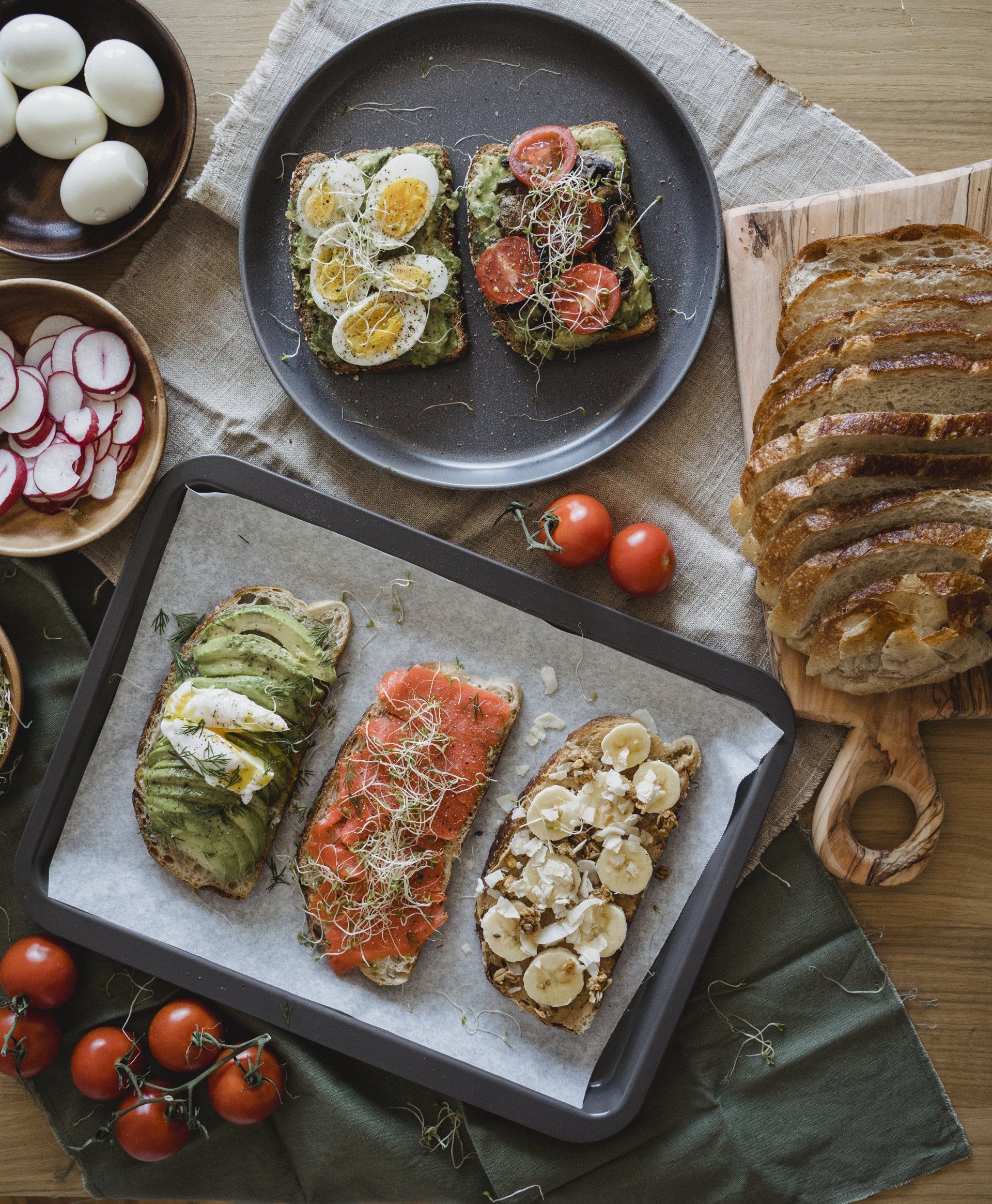 A variety of bread, vegetables, and eggs on serving trays