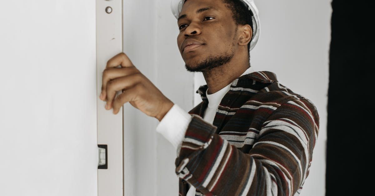 a man is using a level to measure a wall .