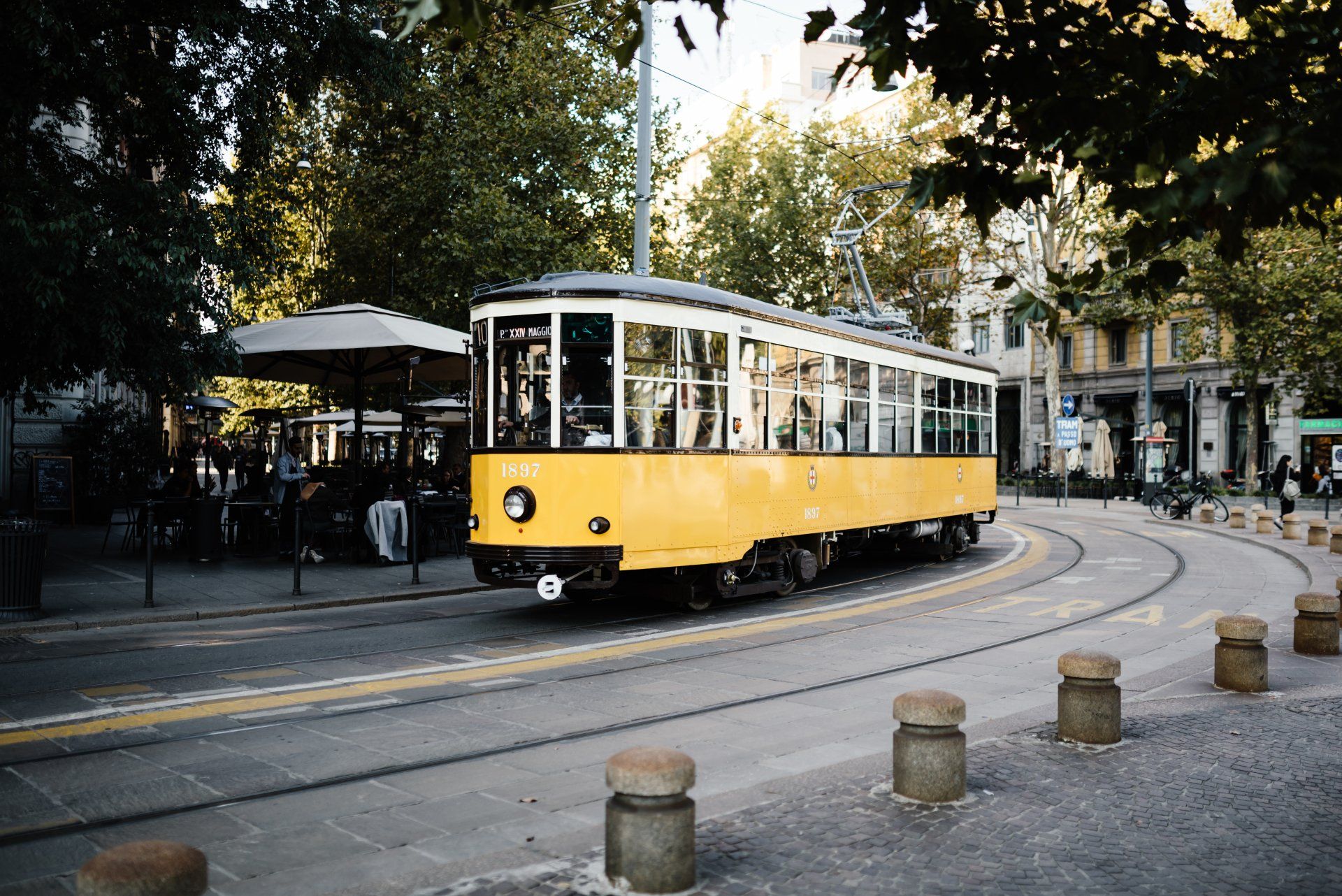 tram giallo e nero di Milano viaggia lungo una strada