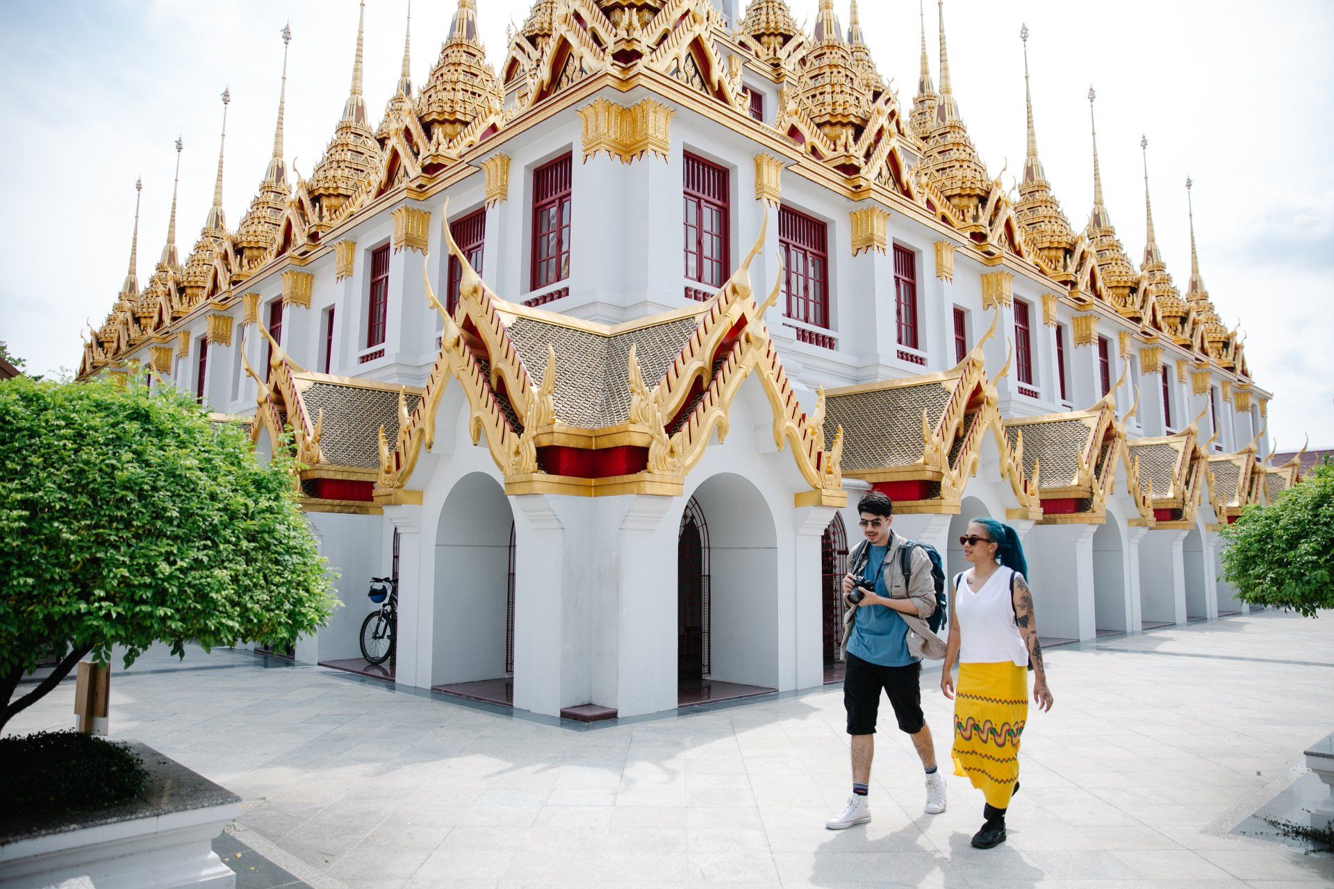 A man and a woman are walking in front of a temple.