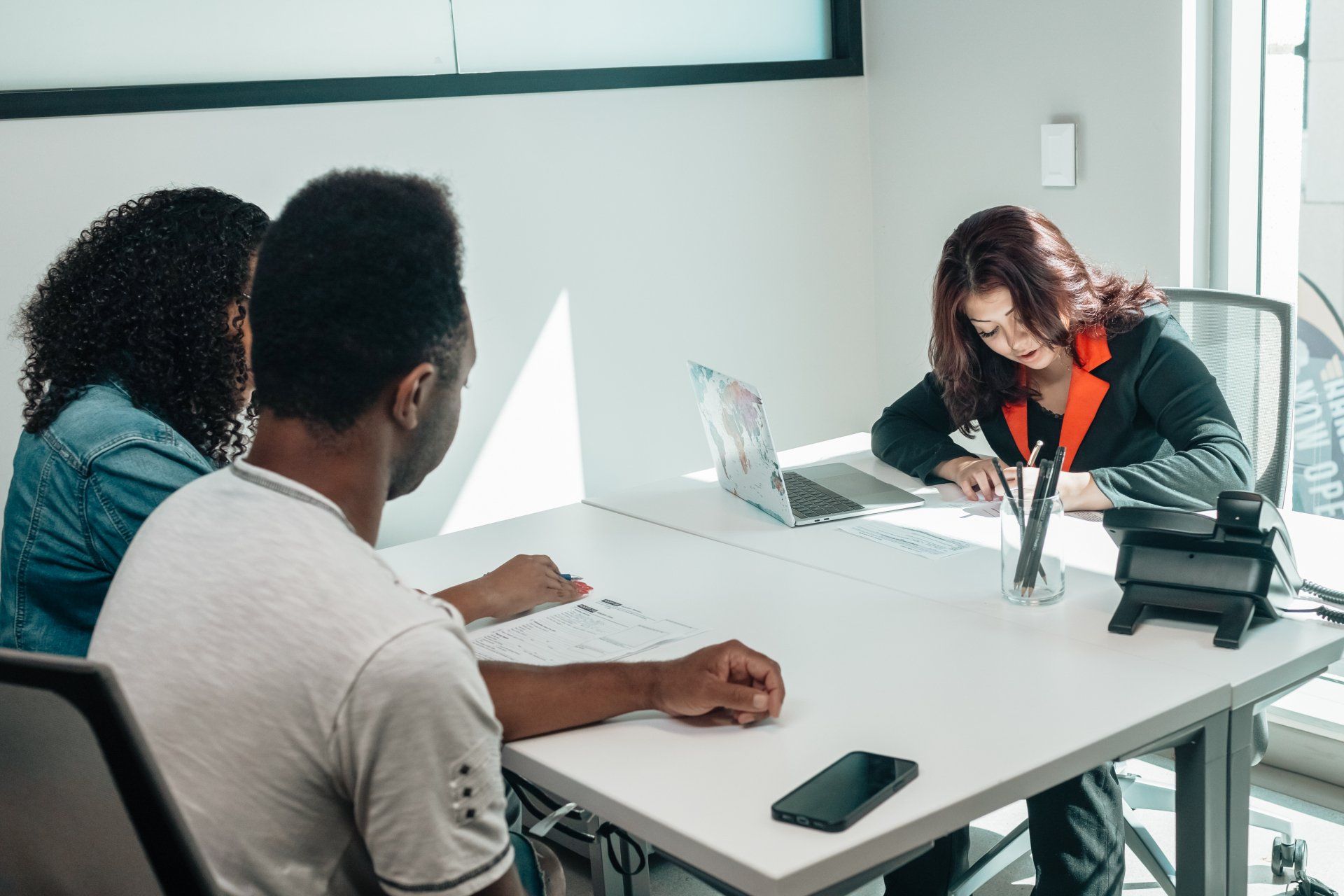 A group of people are sitting at a table with a laptop.