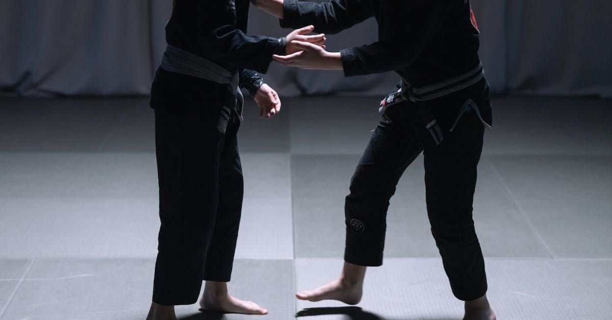 A couple of people are standing next to each other on a mat.