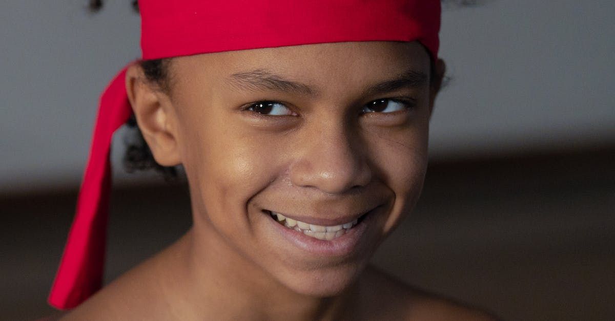 A young boy wearing a red headband is smiling for the camera.