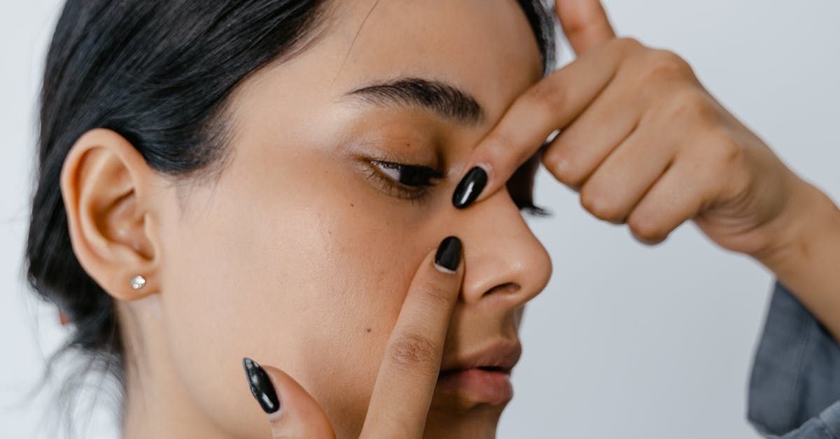 a woman is pinching her nose with her fingers .