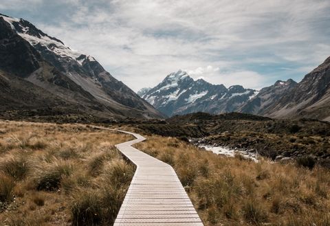 Wooden walkway leading to a mountain range