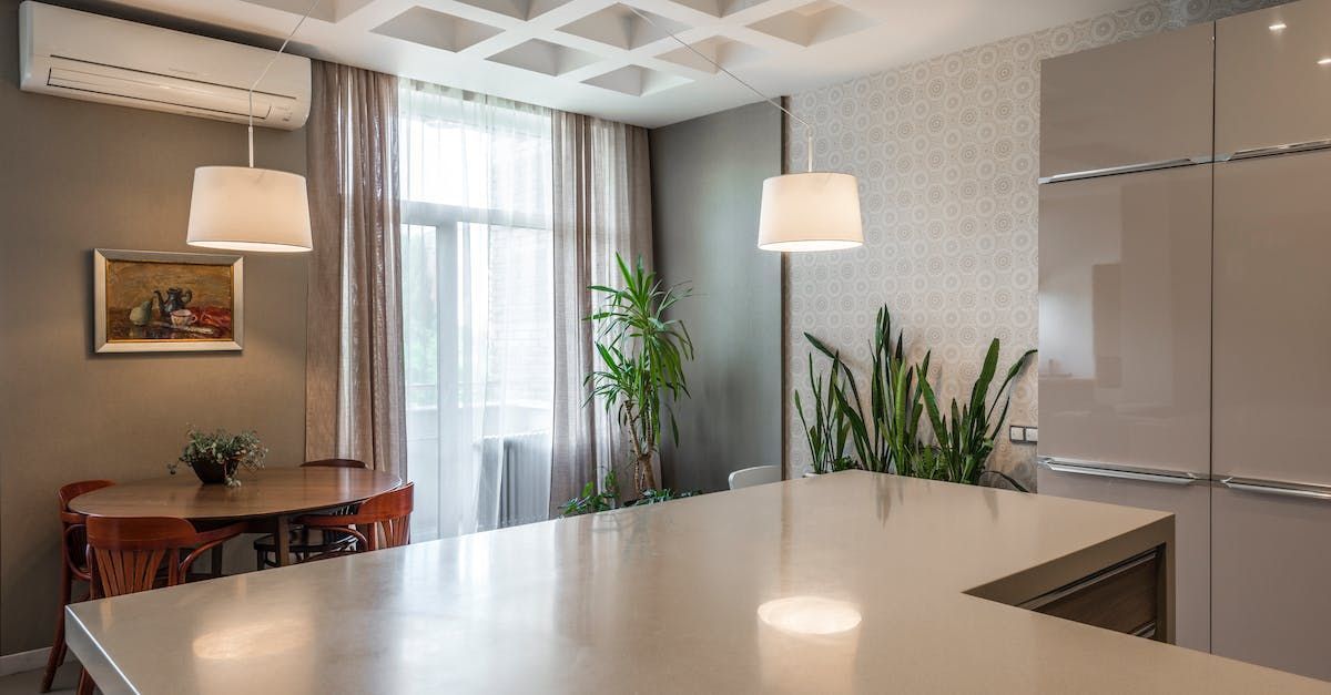 A kitchen with a table and chairs and a large island in the middle of the room.