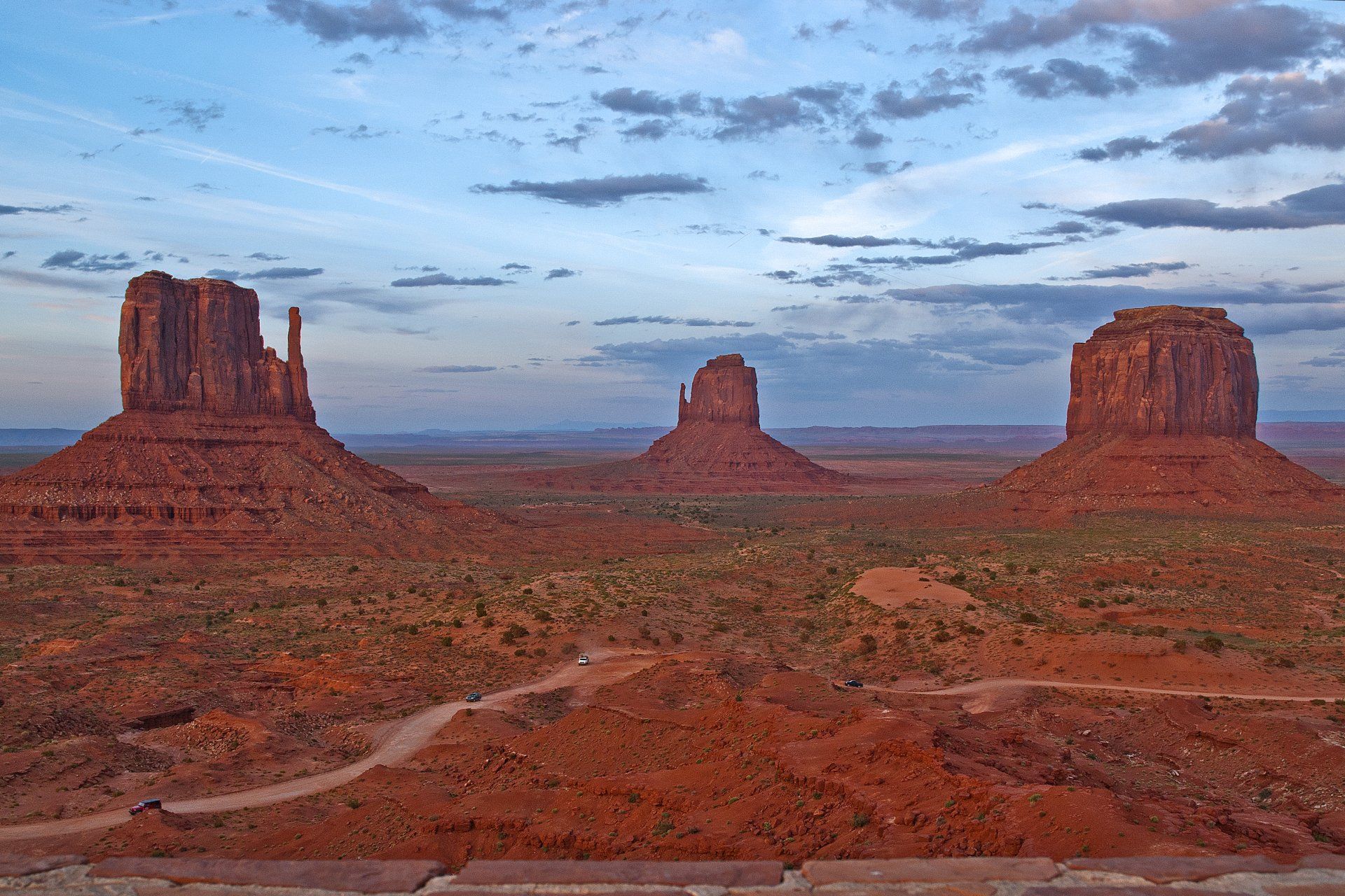 A desert landscape with three rock formations in the foreground