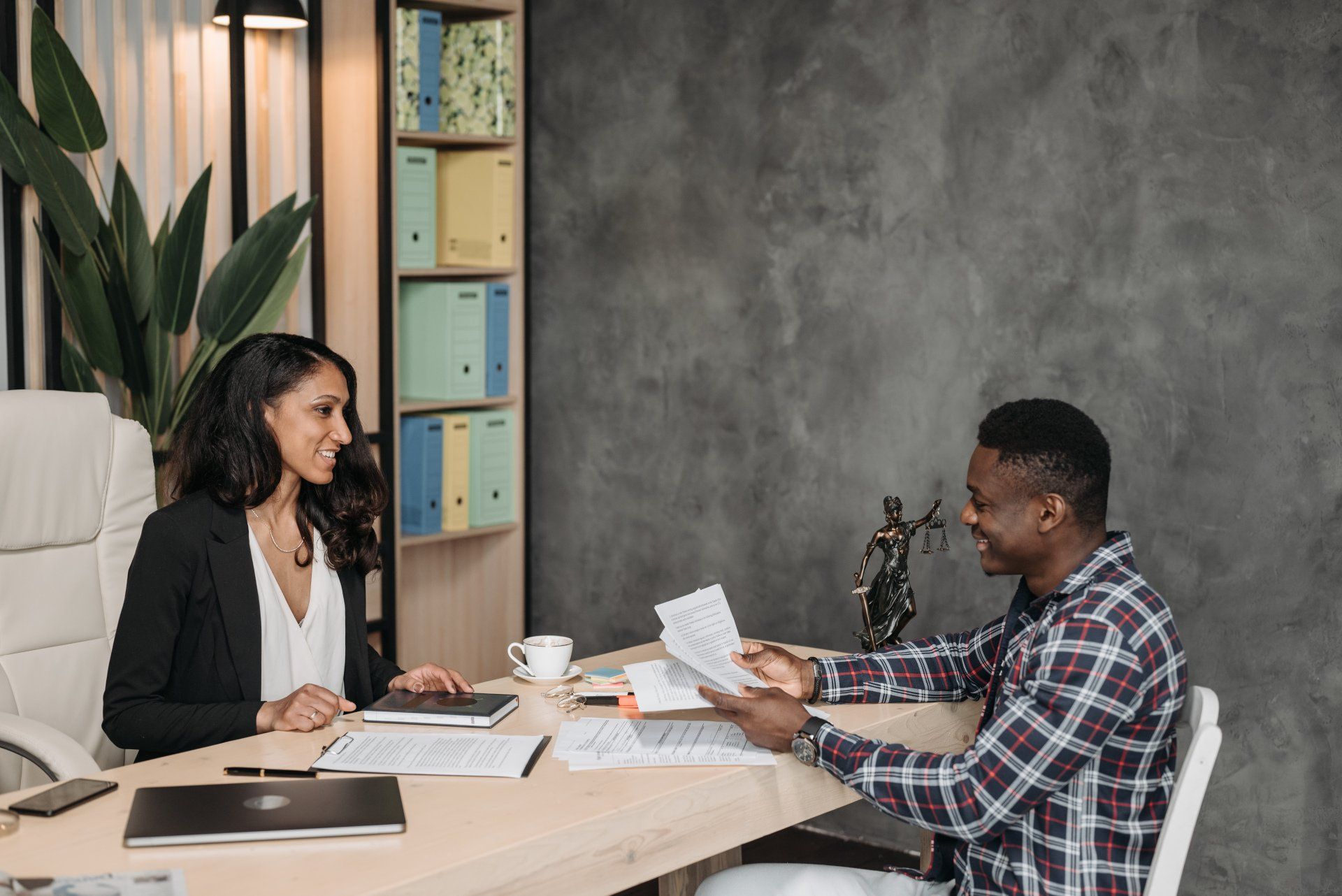 A man and a woman are sitting at a table talking to each other.