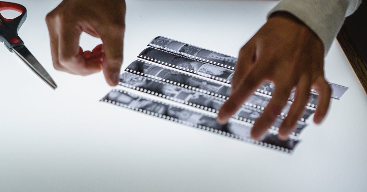 A person is cutting a piece of film with scissors