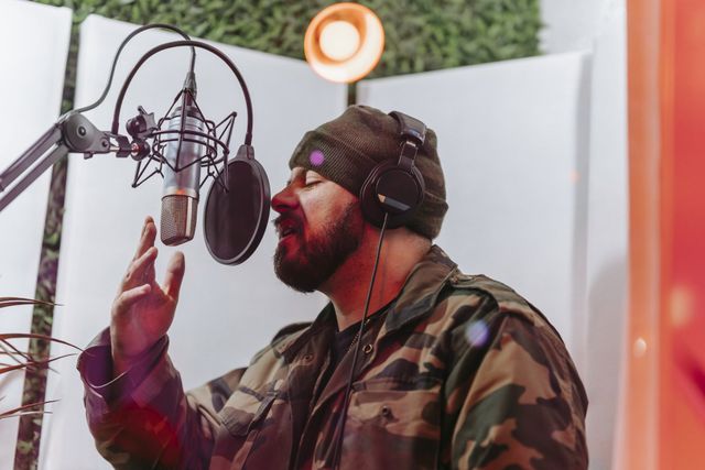 A man in a camouflage jacket is singing into a microphone.