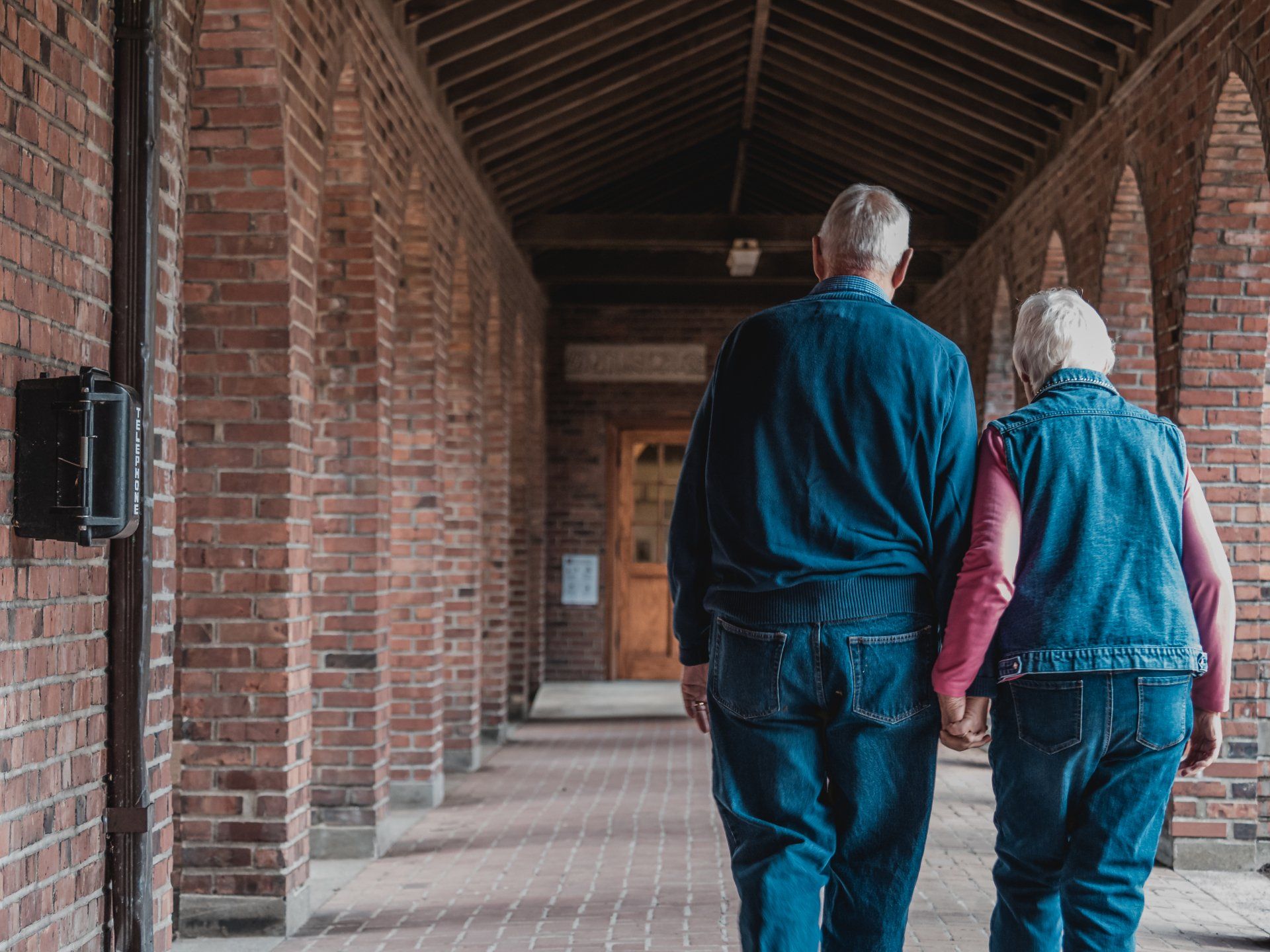 Elderly couple walking with back to audience.