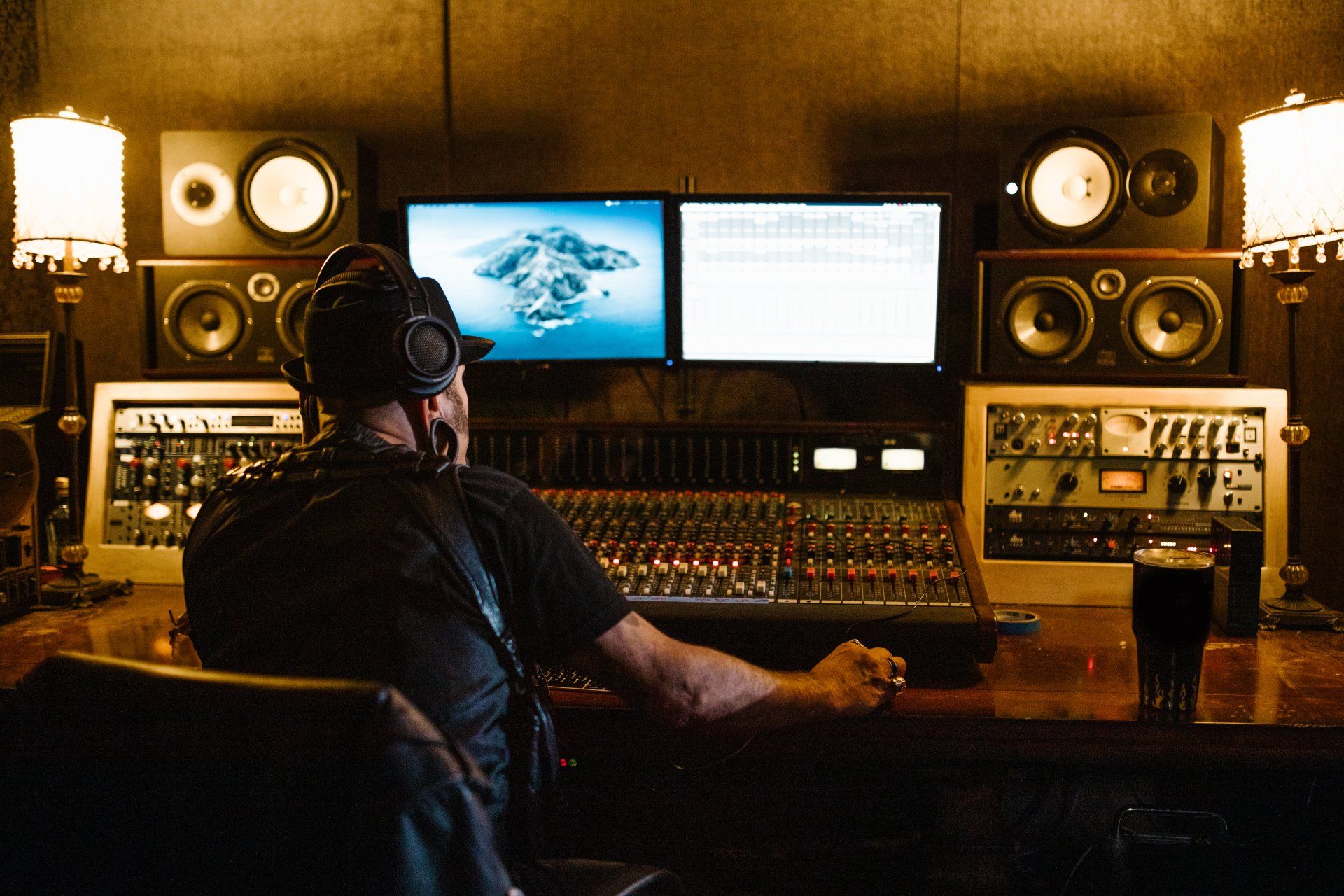 A man is sitting at a desk in a recording studio.