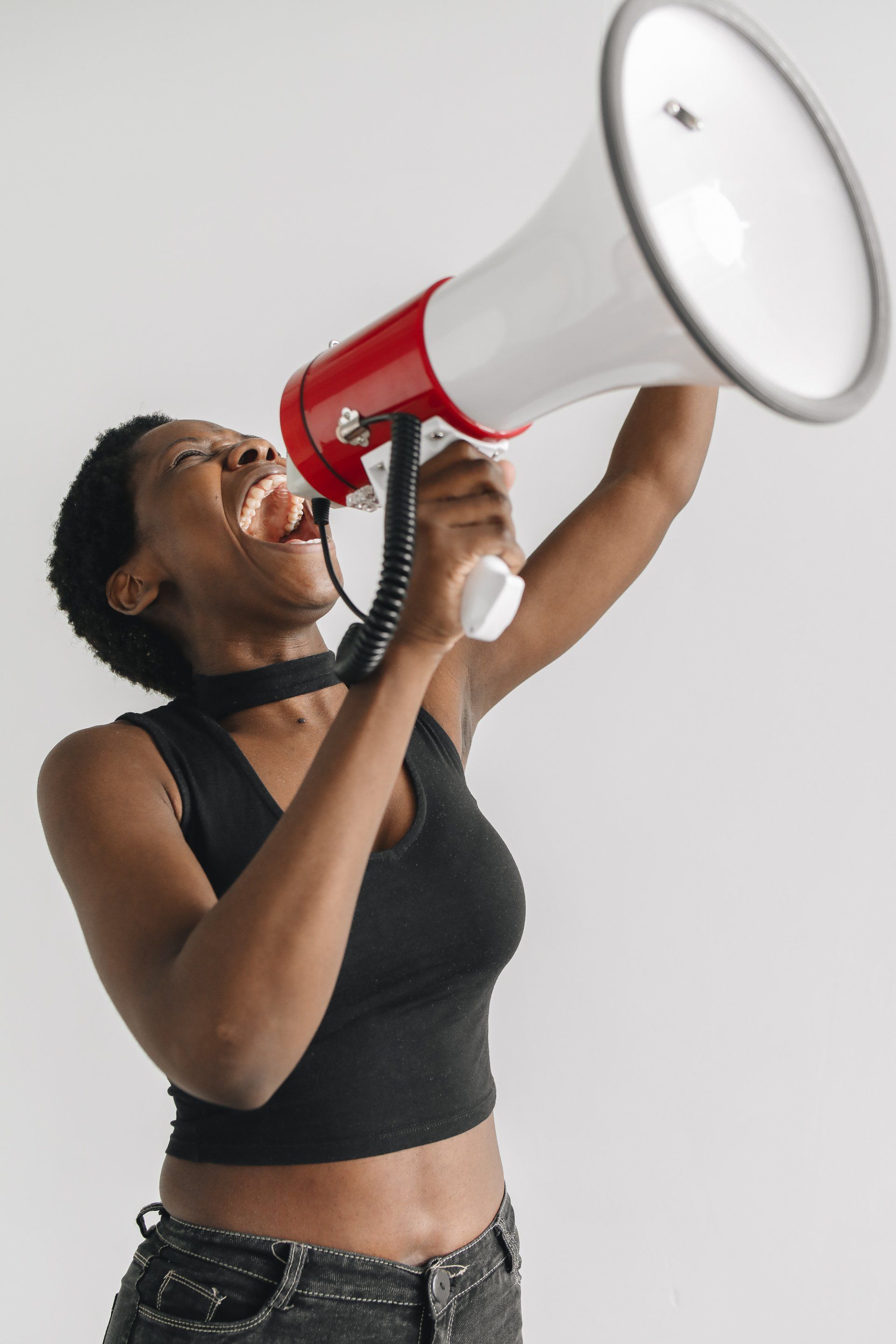 Woman with arm in the air shouting through megaphone