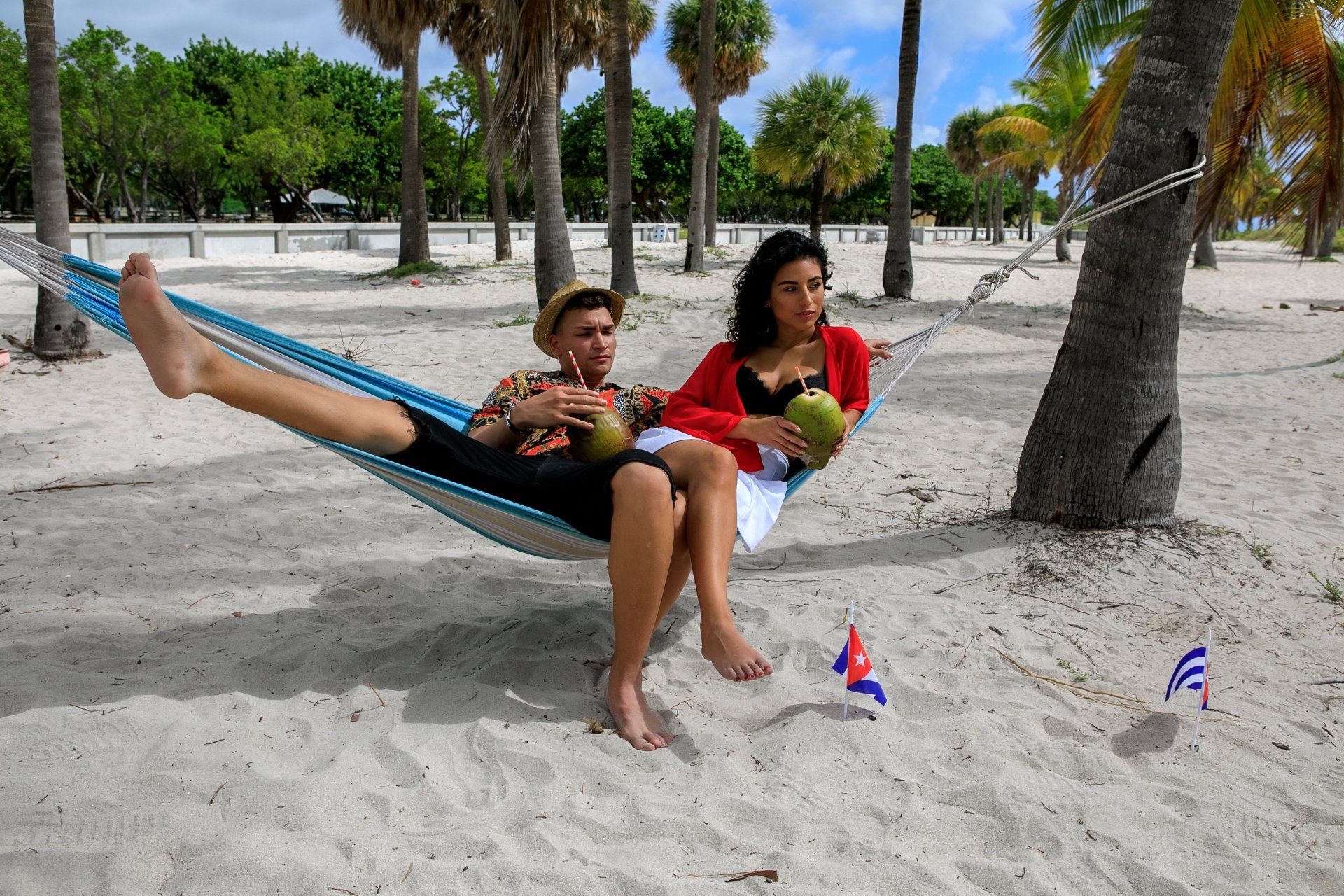 A couple sitting in a hammock on a beach in Cuba.