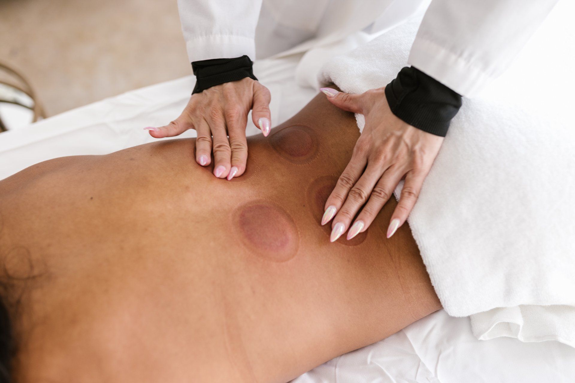 A woman is getting a massage on her back at a spa.