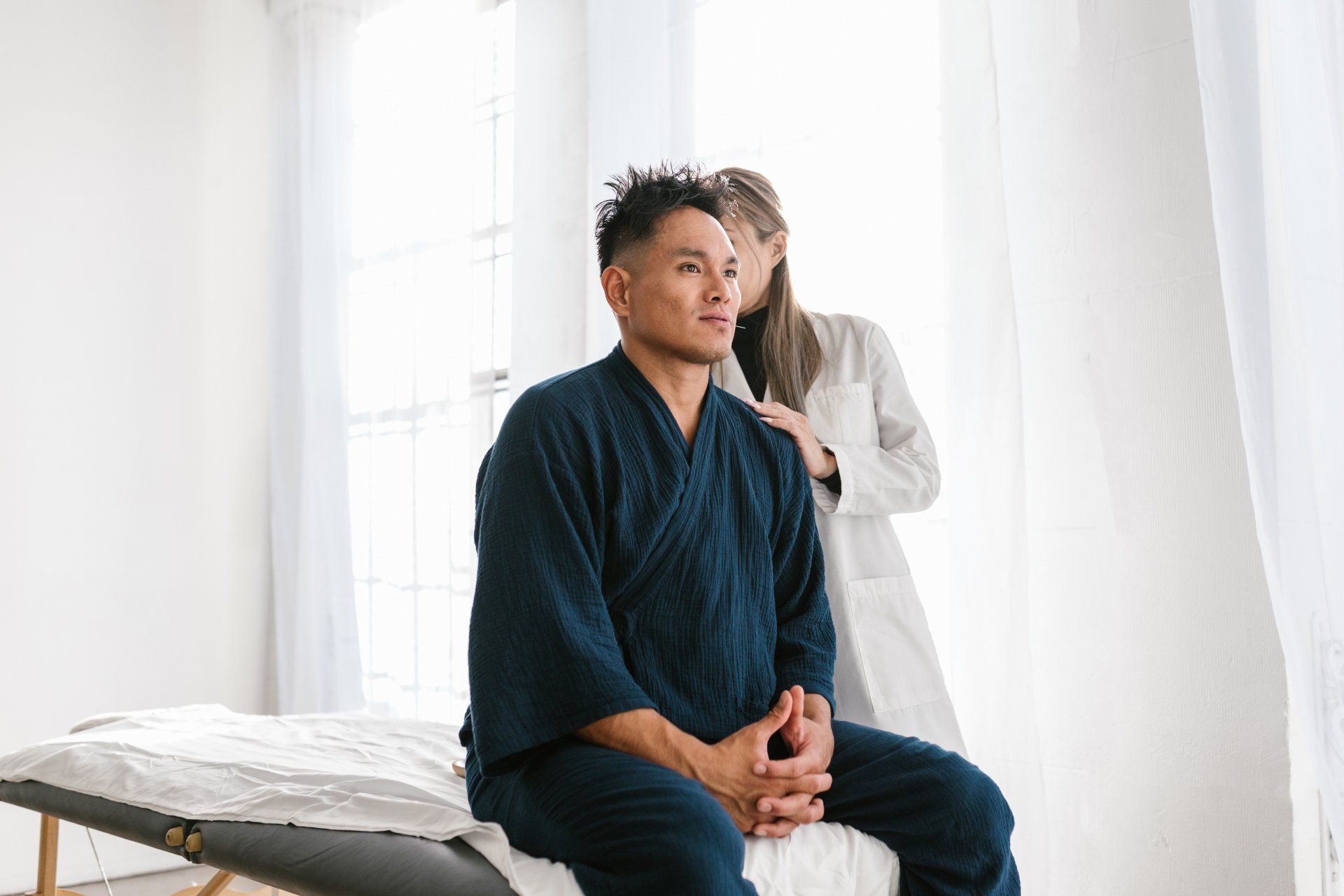 patient sitting while a doctor is checking on him